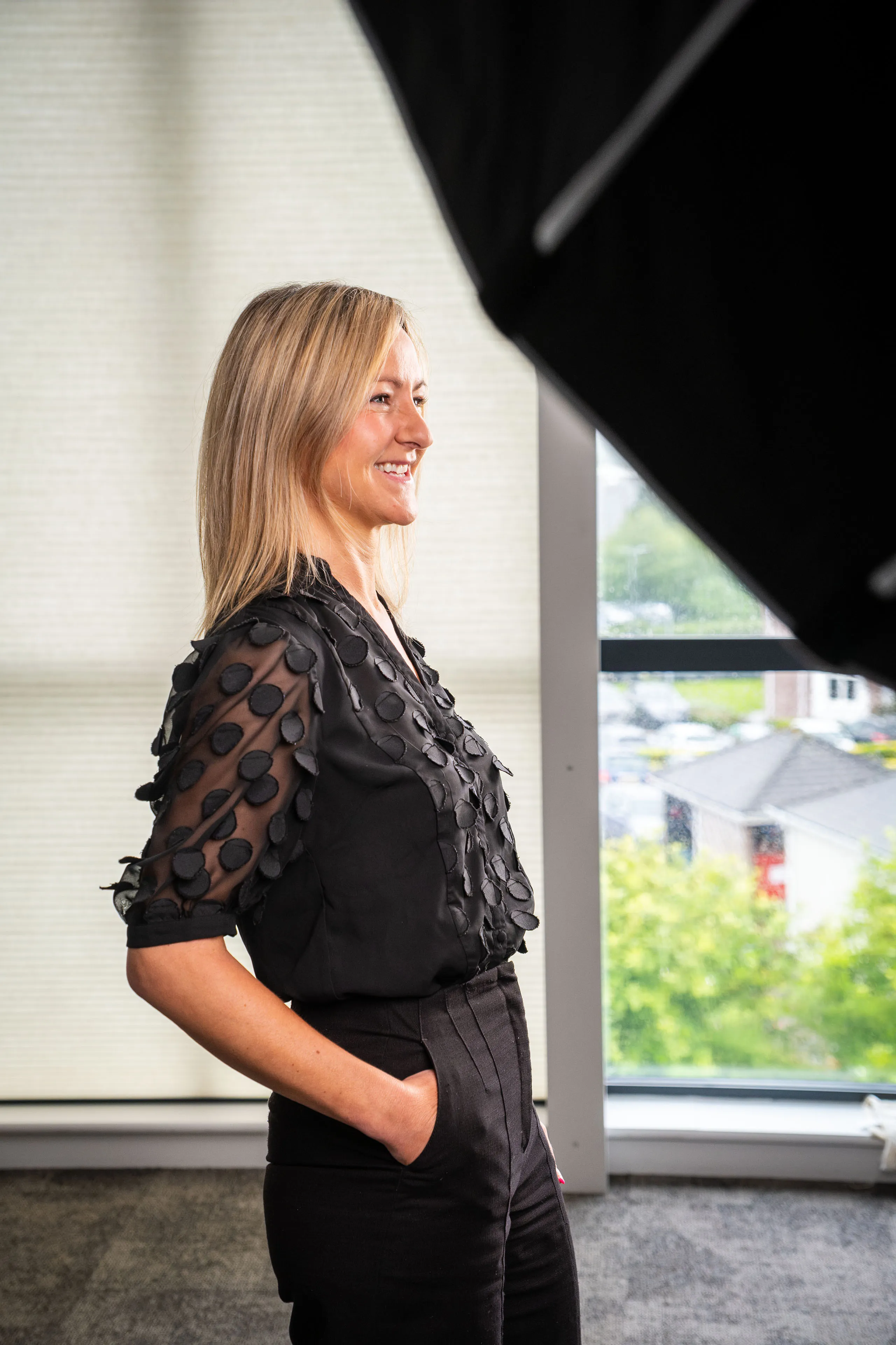 Sue Coniglio-Burrows smiling during her portrait session for Boal & Co, with studio lighting visible in the background