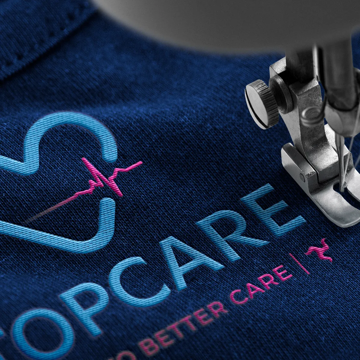 TopCare logo embroidered onto a navy polo shirt, showing the brand identity designed by DotPerformance for the Isle of Man healthcare provider