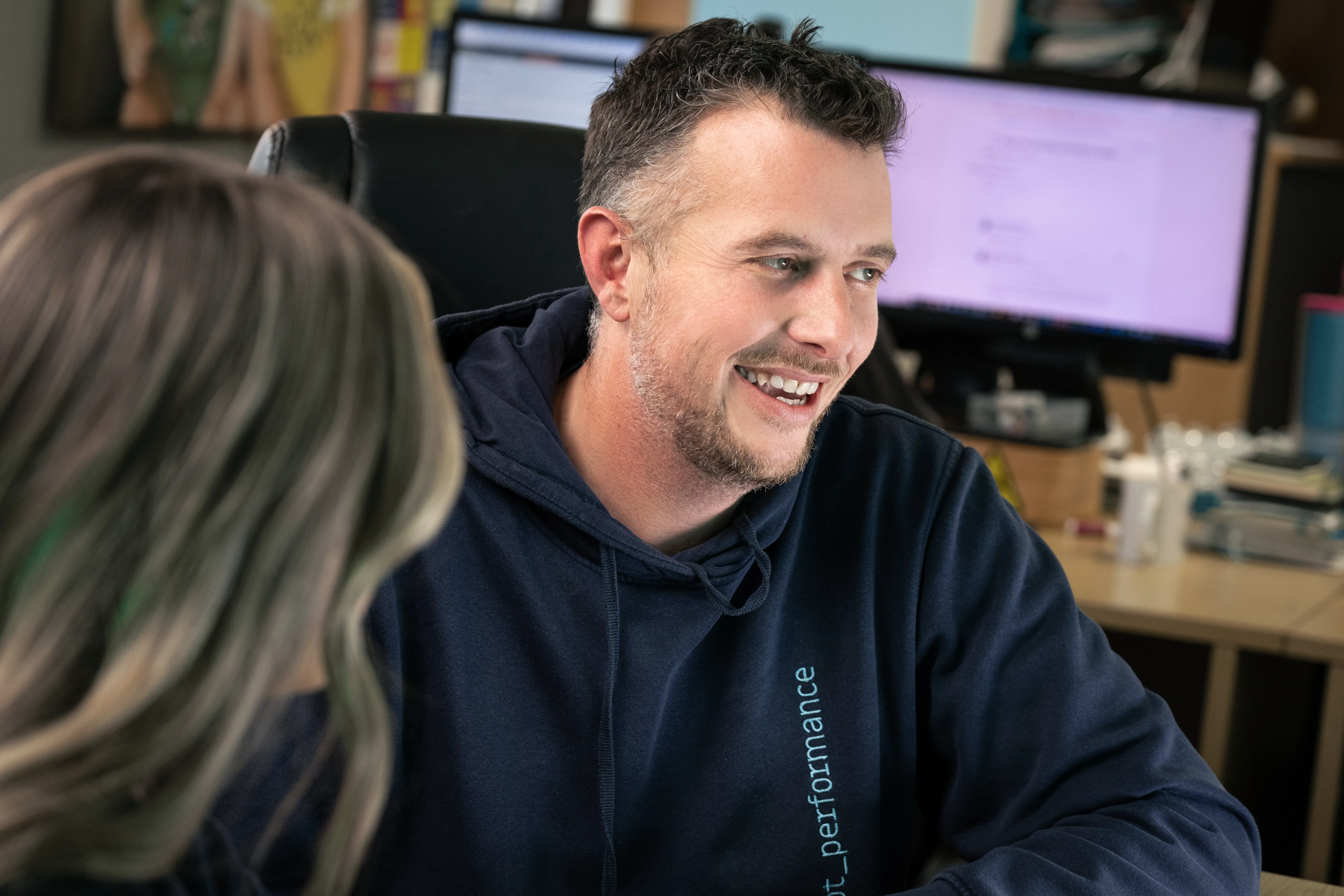 Andy Orton listening during a conversation with a colleague in the office