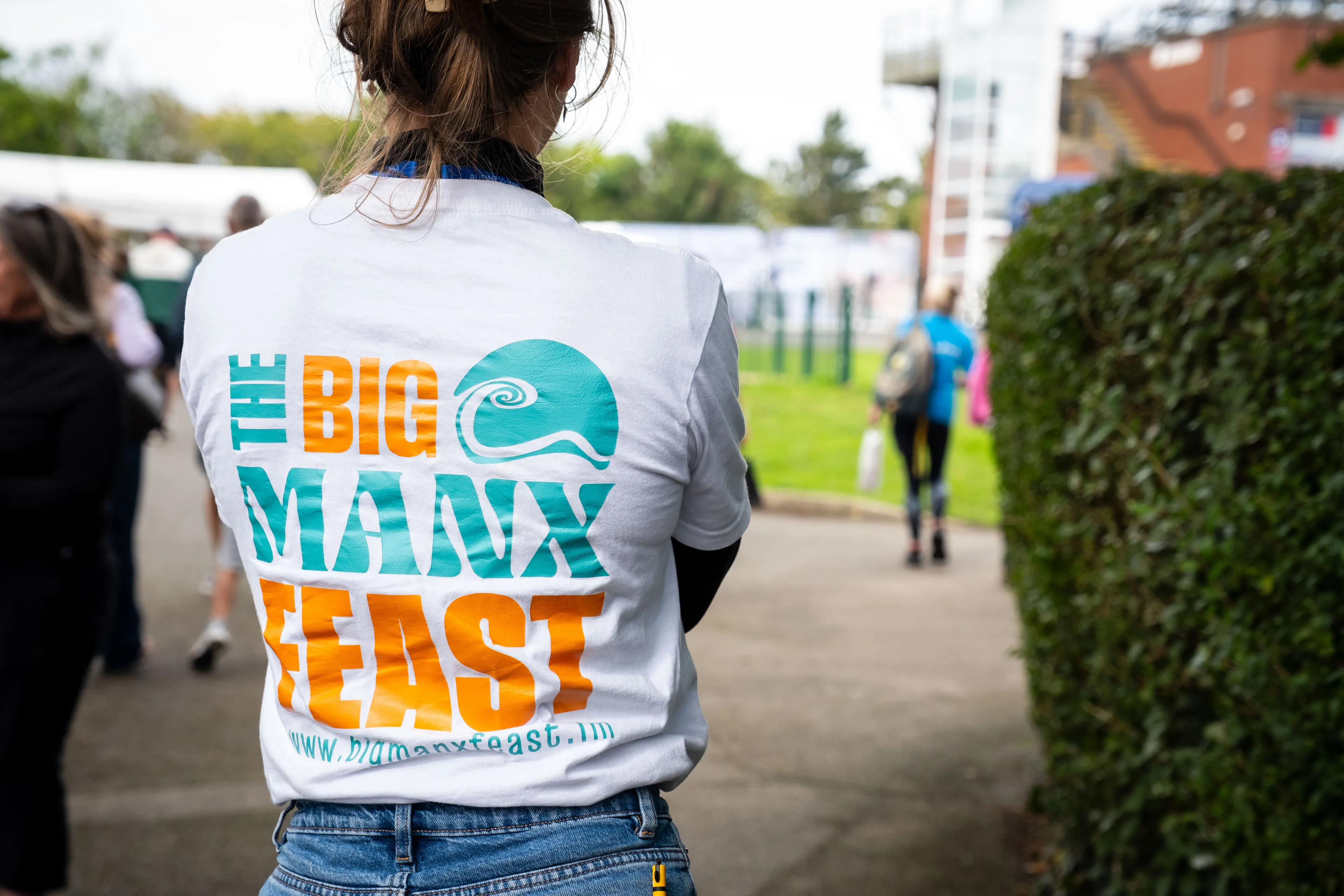 Close-up of "The Big Manx Feast" logo printed on the back of a visitor's t-shirt