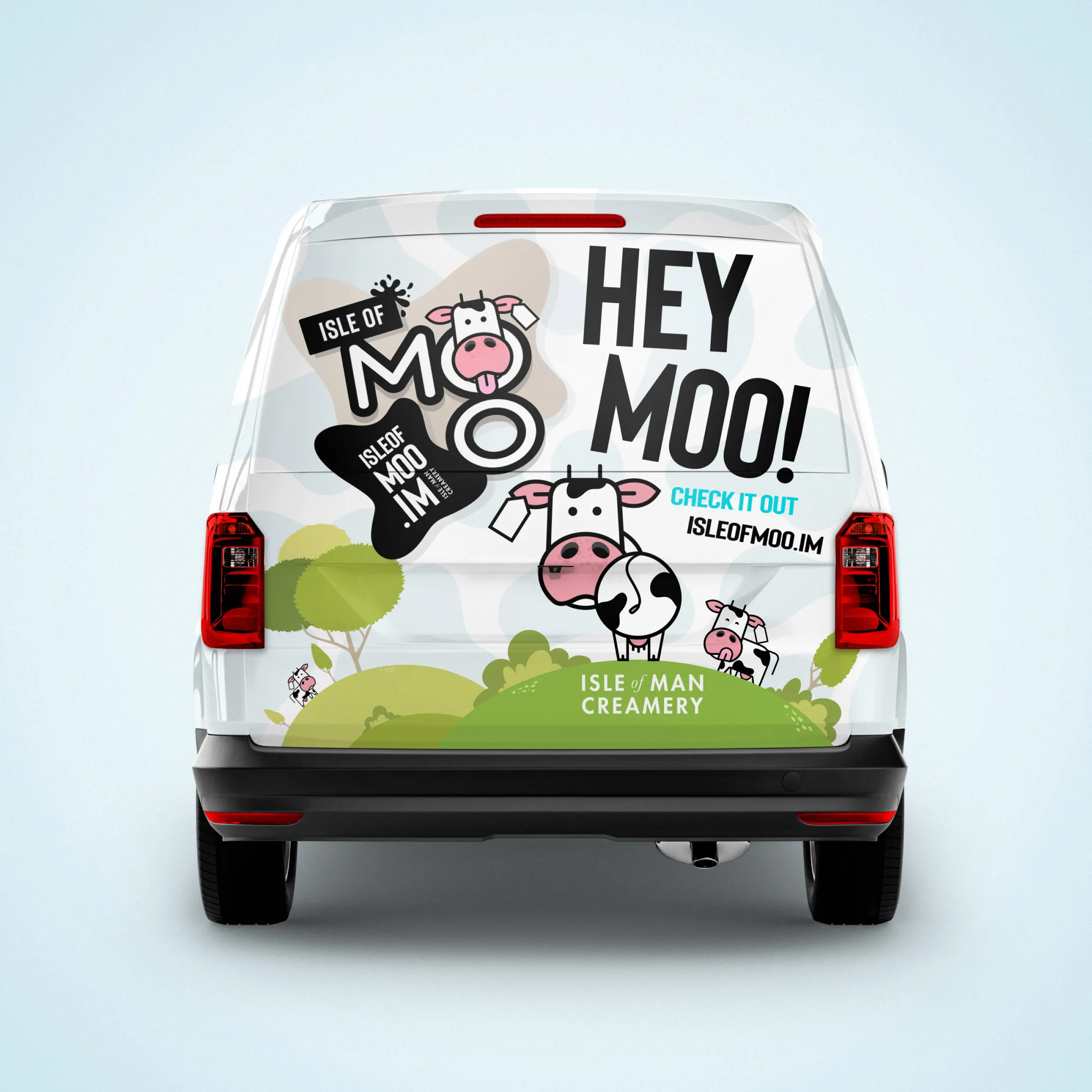 Rear view of a delivery van with “Hey Moo!” branding, cartoon cow graphics, and promotional messaging for Isle of Man Creamery.