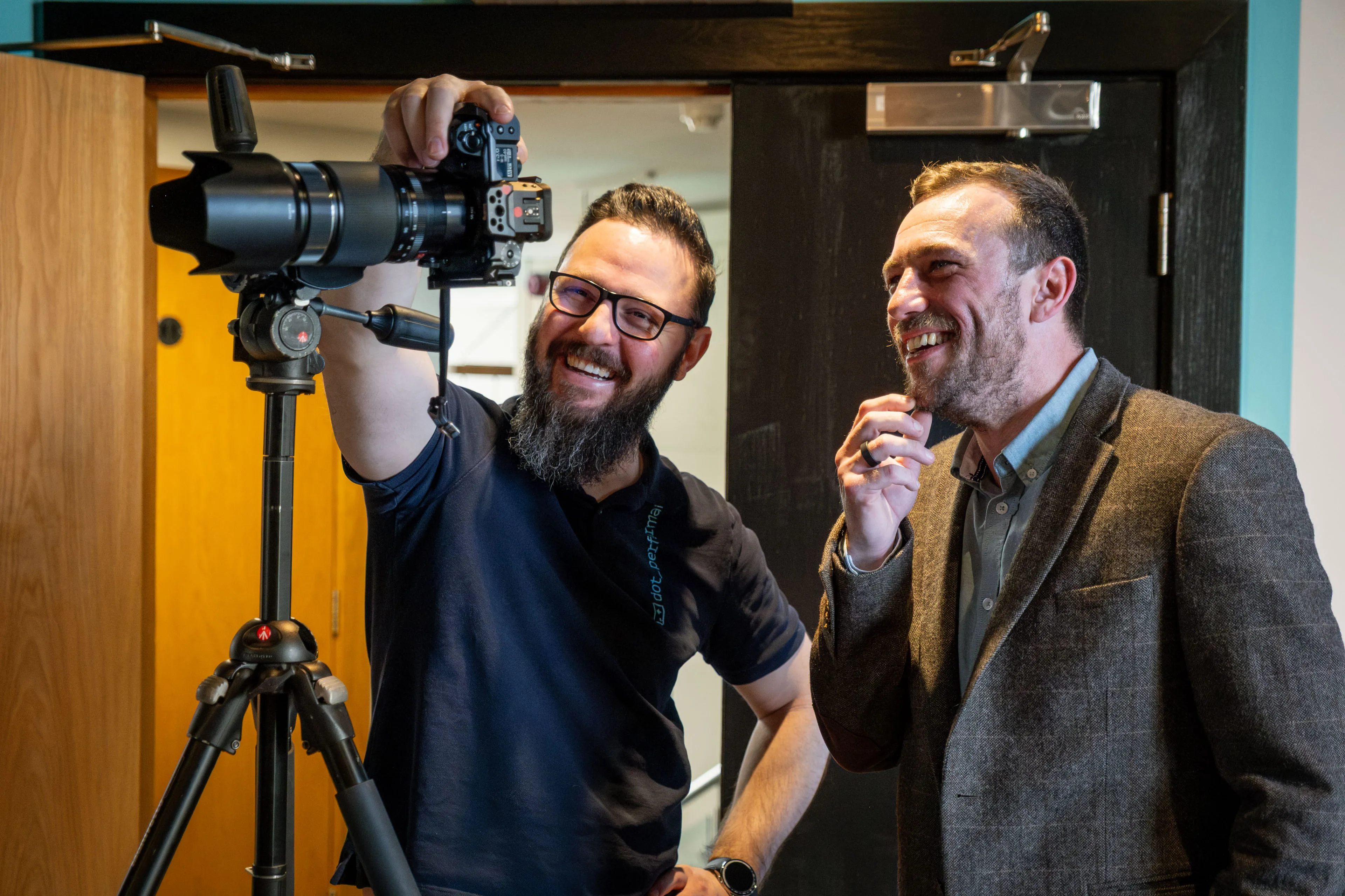Nico van Loggerenberg adjusting the camera framing while reviewing headshots with an ECAP employee at DotPerformance Studio