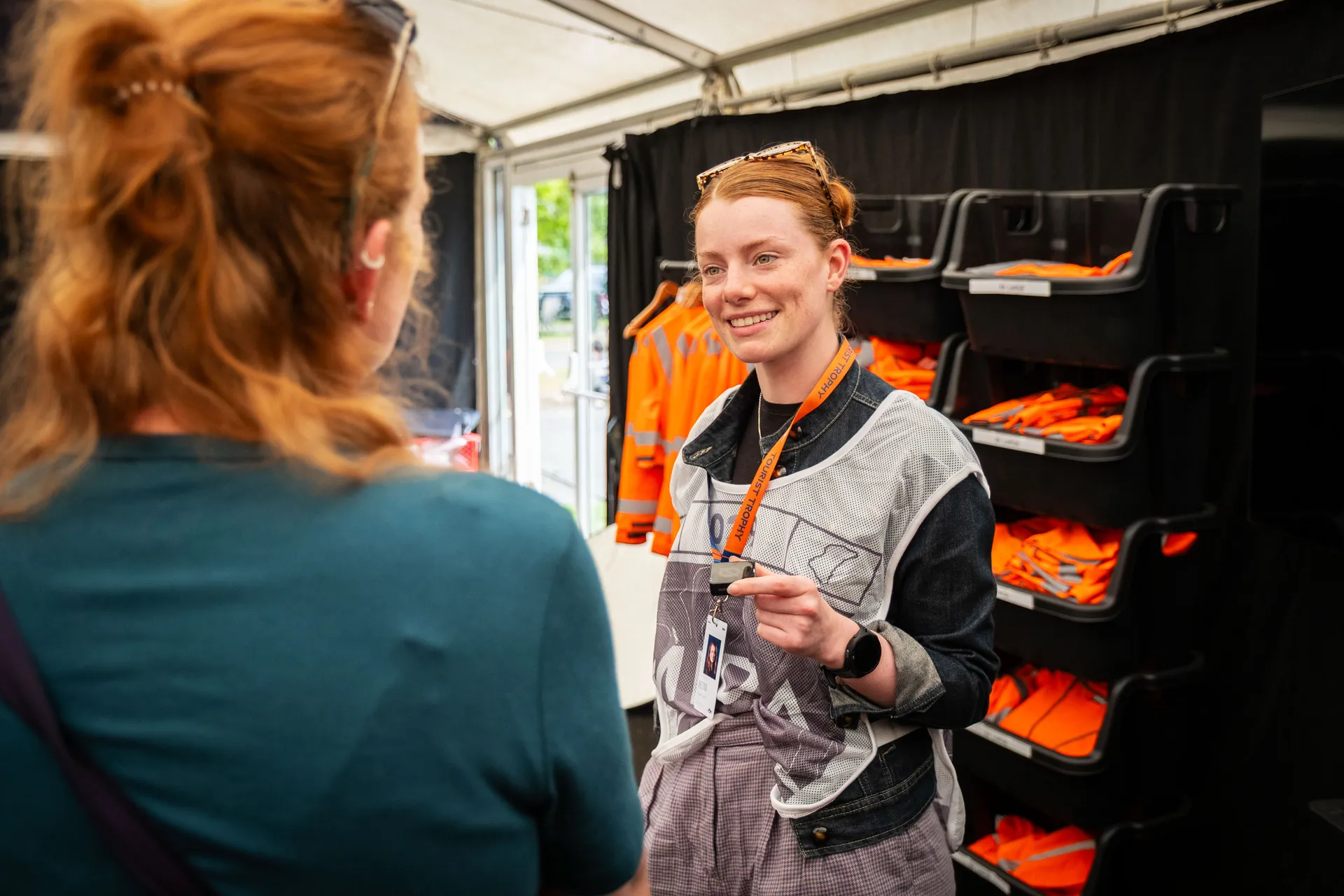 A marshal in her tabard smiling inside a TT Marshals tent