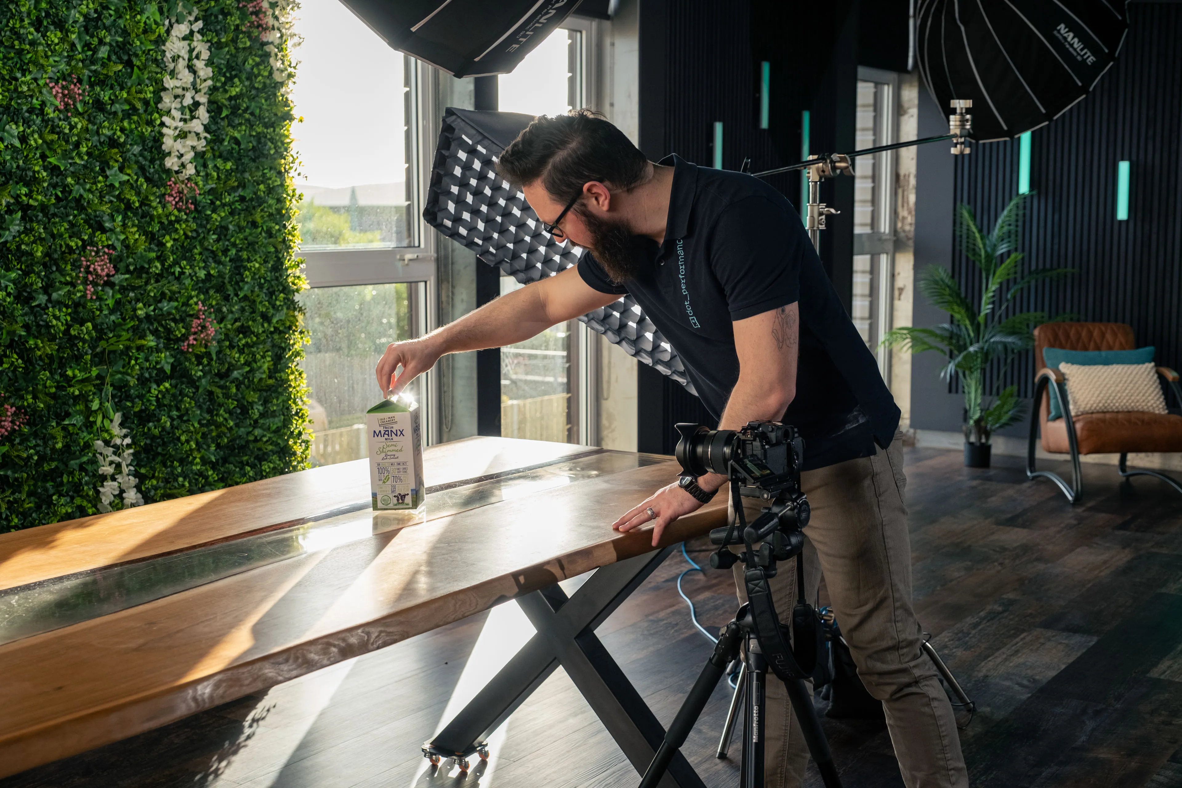 Nico van Loggerenberg setting up a product photography shot of an Isle of Man Creamery carton of milk at DotPerformance studios on the Isle of Man, using Nanlite softbox lighting and a Fujifilm XH2s on tripod