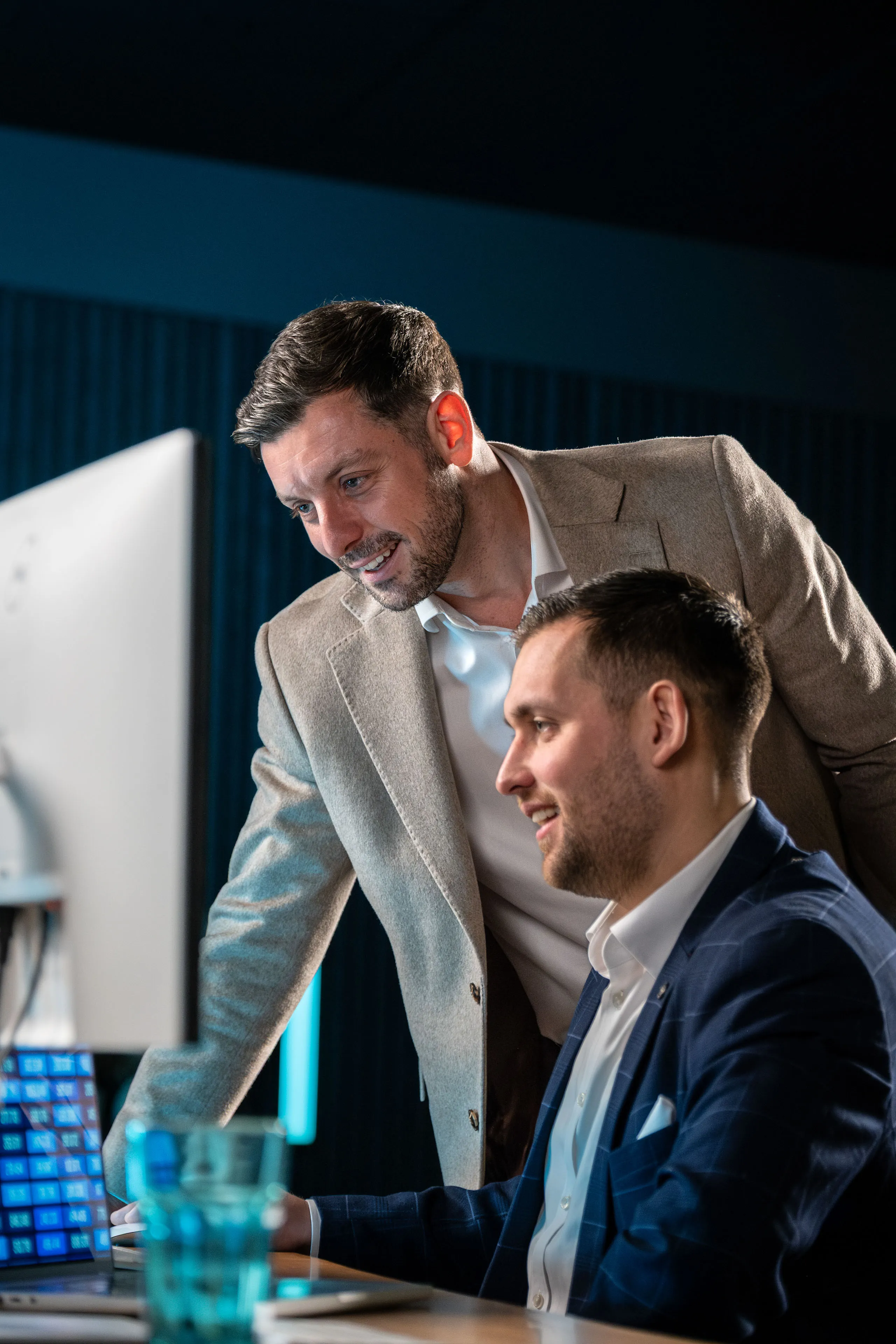 Dan Collier pointing something out on a monitor to Brook Longhurst as they go through work together