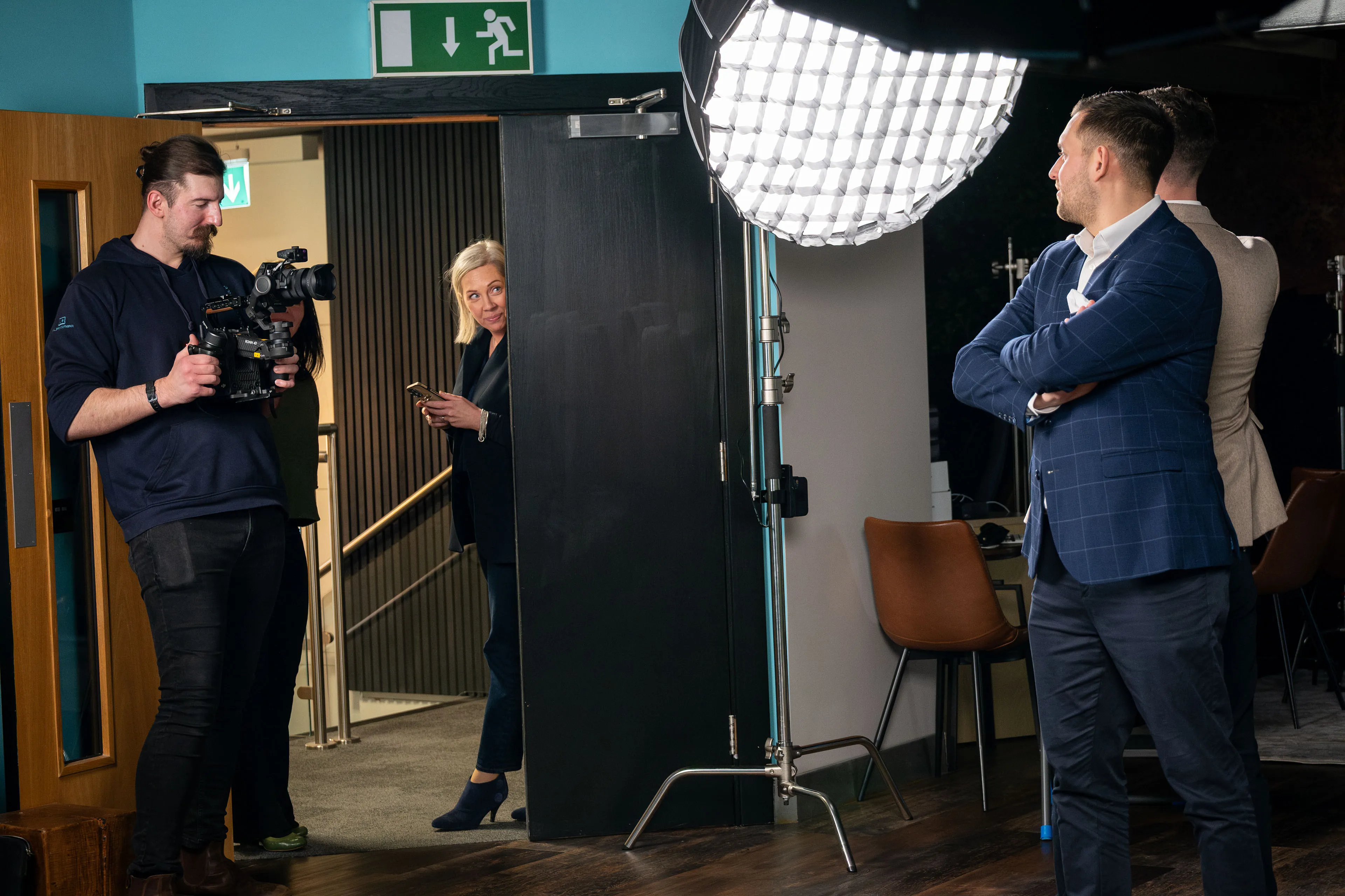 Filmmaker Will Oates filming with a gimbal camera as Lisa Karran looks on and the ECAP founders wait beside the softbox lighting setup
