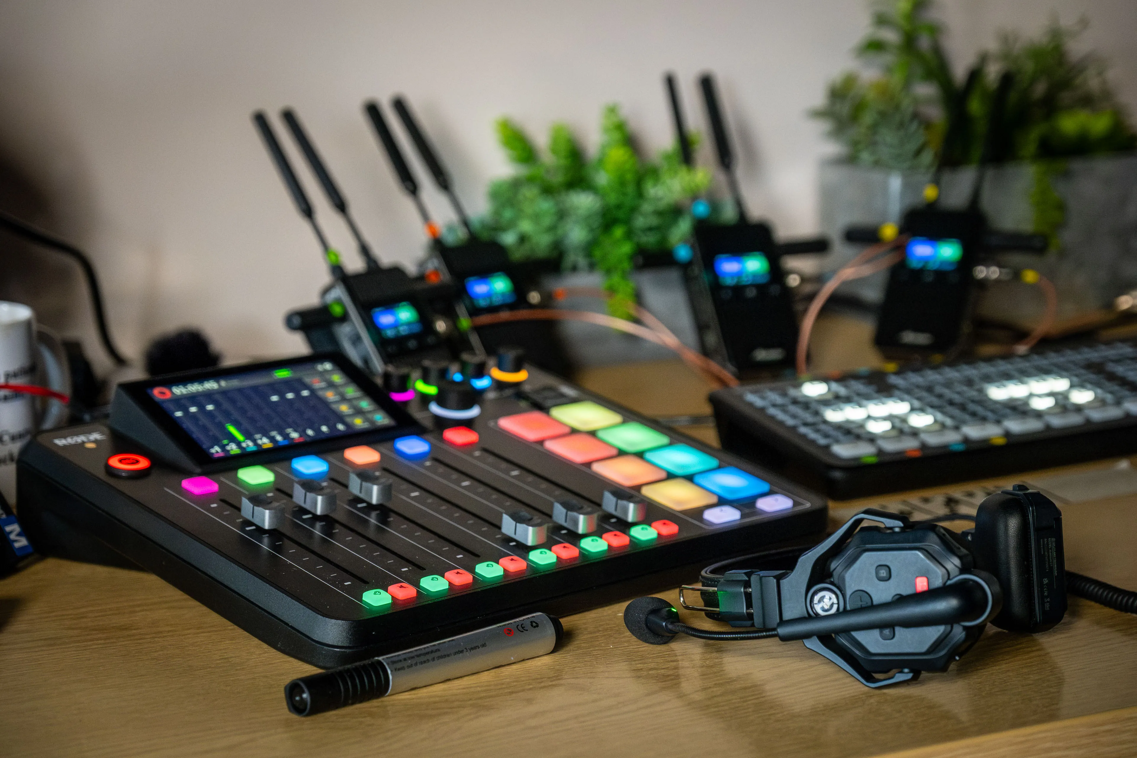 DotPerformance podcast studio control desk showing a Rode audio mixer, wireless transmitter units, headphones and a Blackmagic ATEM switcher panel used during multi-camera interview productions on the Isle of Man