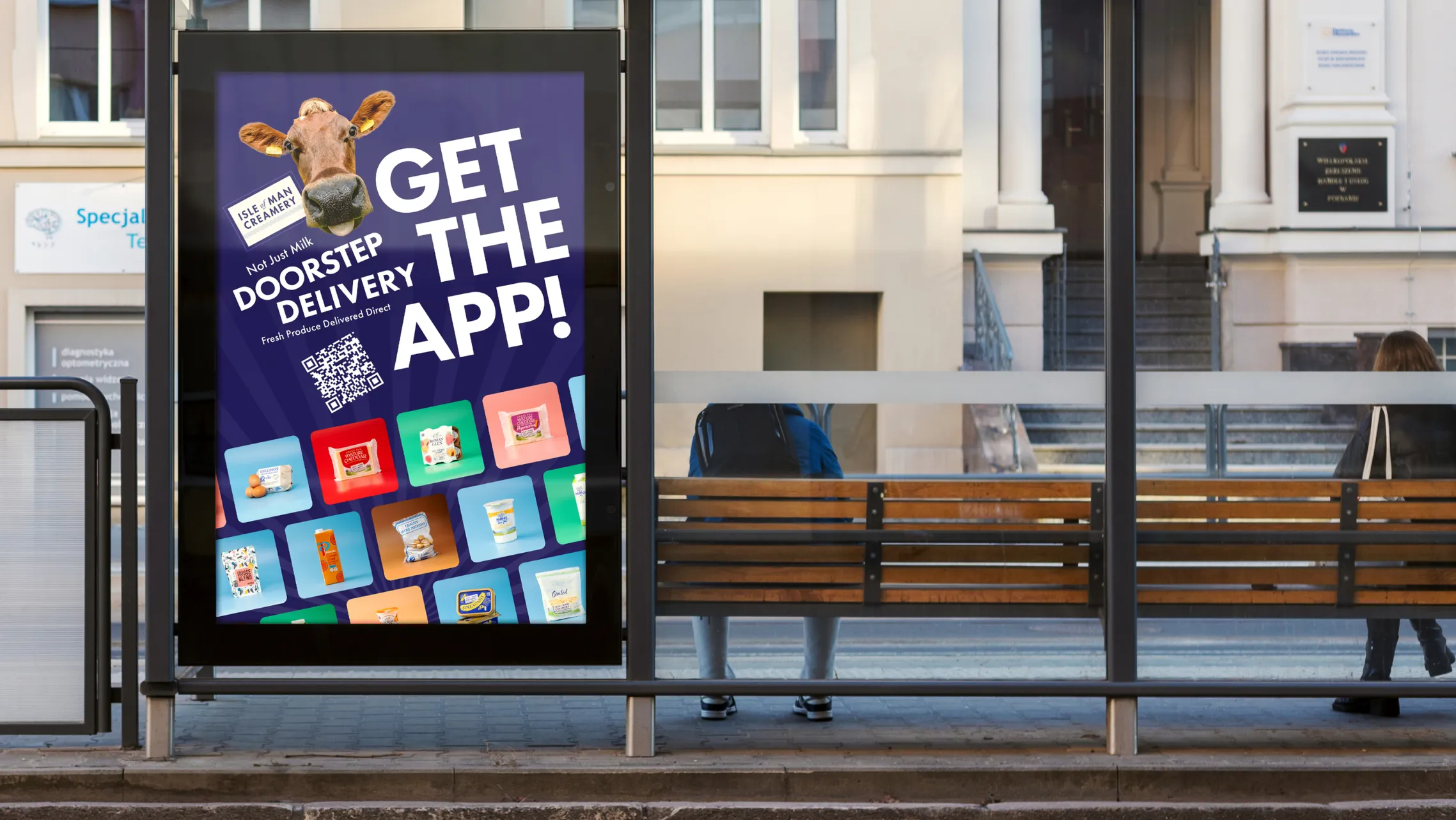 Isle of Man Creamery Doorstep Delivery digital bus stop advertisement designed by DotPerformance, showing the Jersey cow mascot, a QR code, and product range with the headline "Get The App"