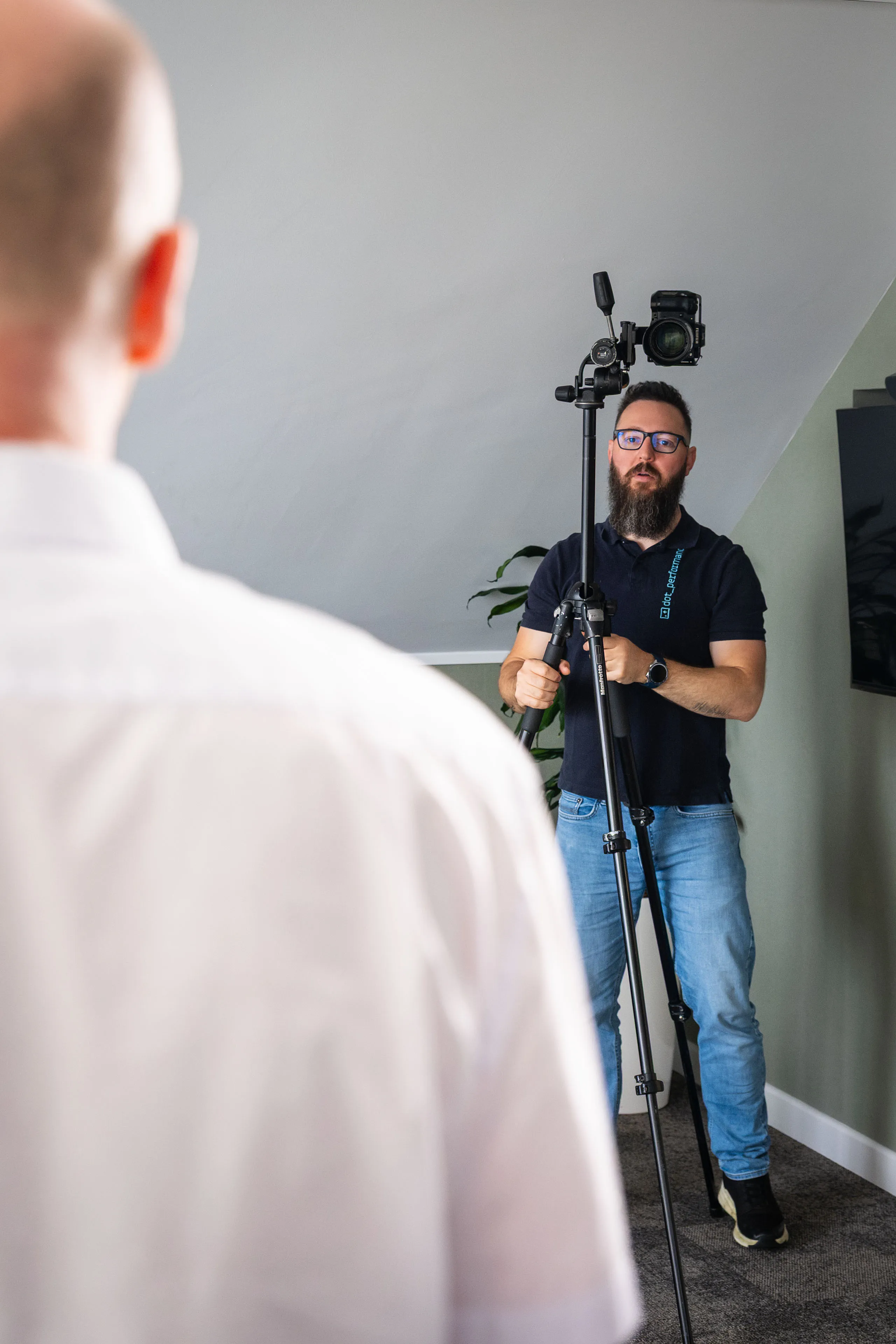 Nico van Loggerenberg adjusting the height of a Fujifilm X-H2S camera on a Manfrotto tripod during a Boal & Co portrait session.