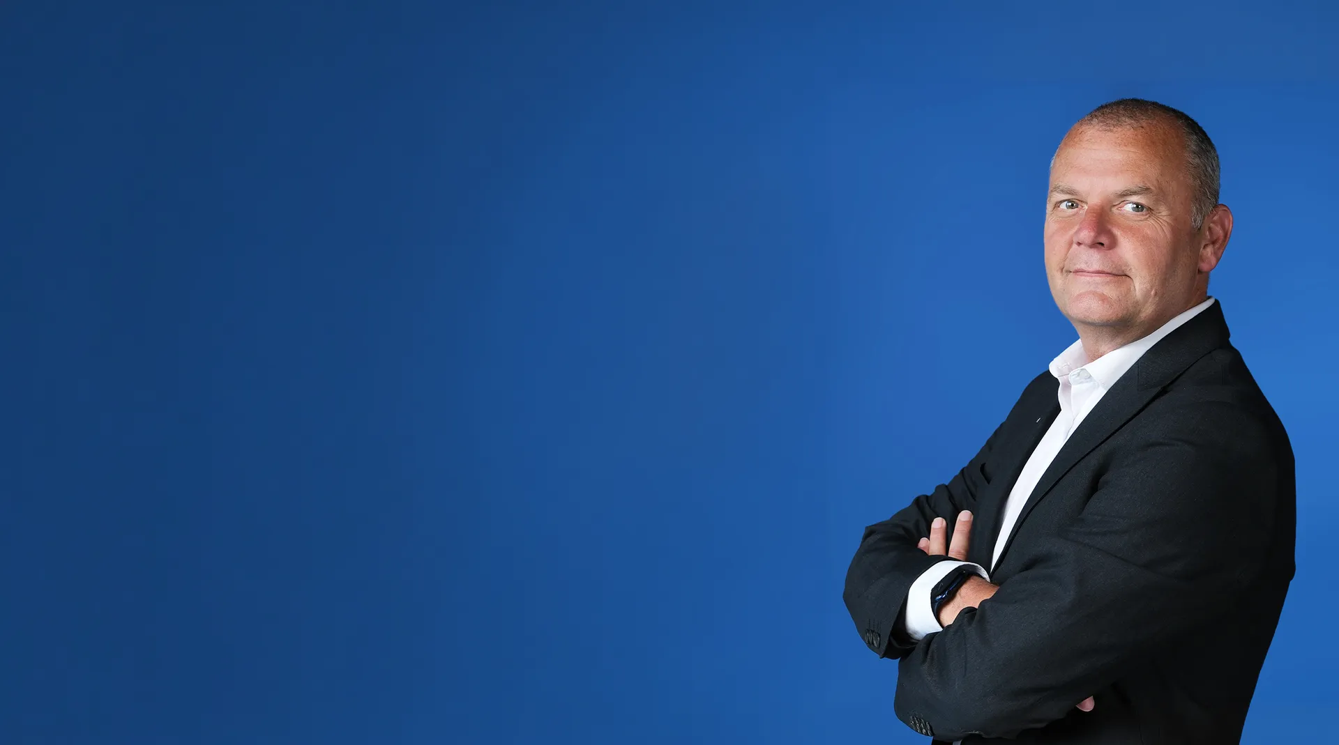 Steve Fletcher of PGi, photographed against a blue backdrop