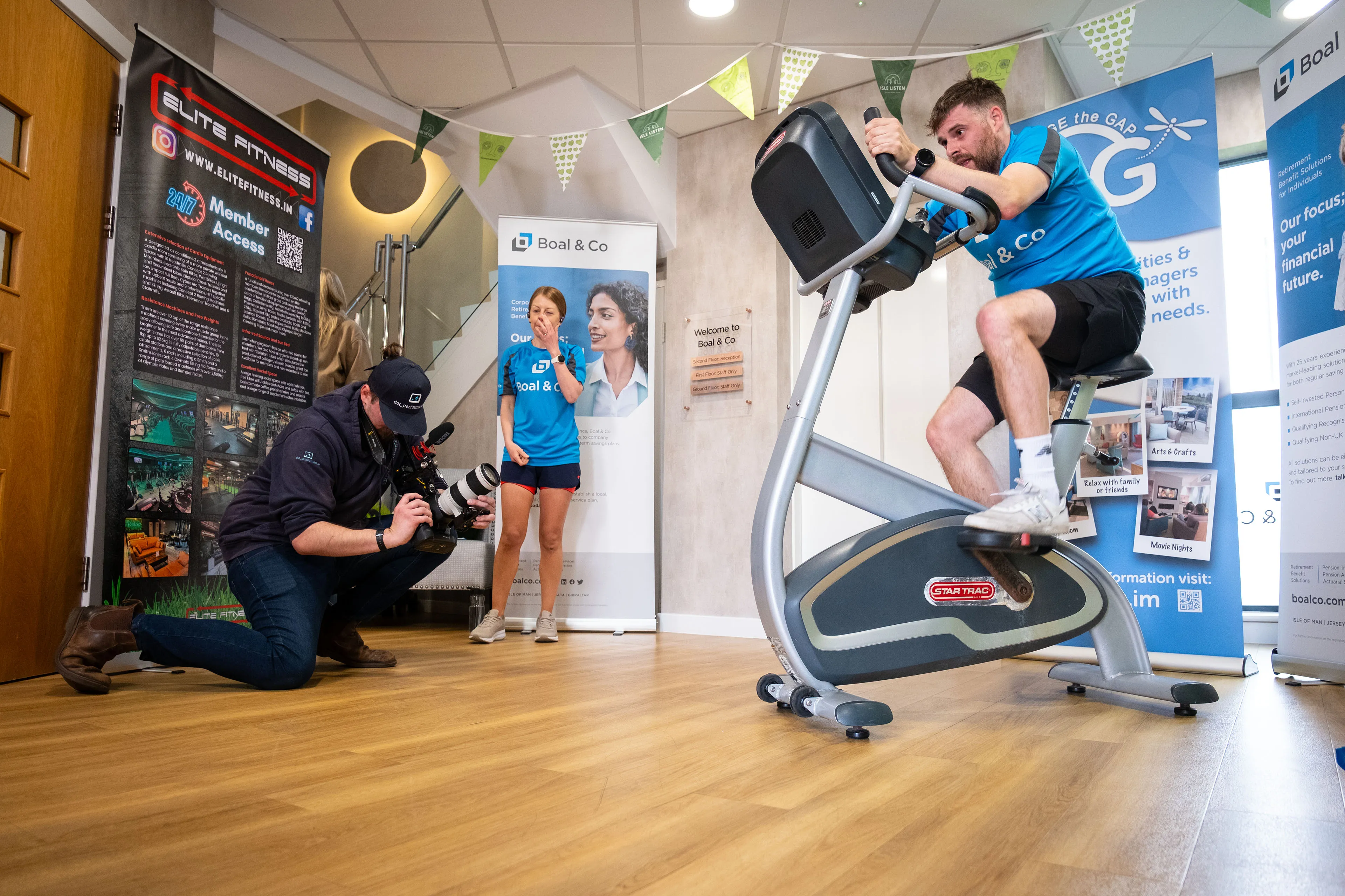 Will Oates from DotPerformance filming a Boal & Co team member cycling on a static bike, shooting low with a Black Magic Pocket 6K at the Boal & Co office on the Isle of Man.