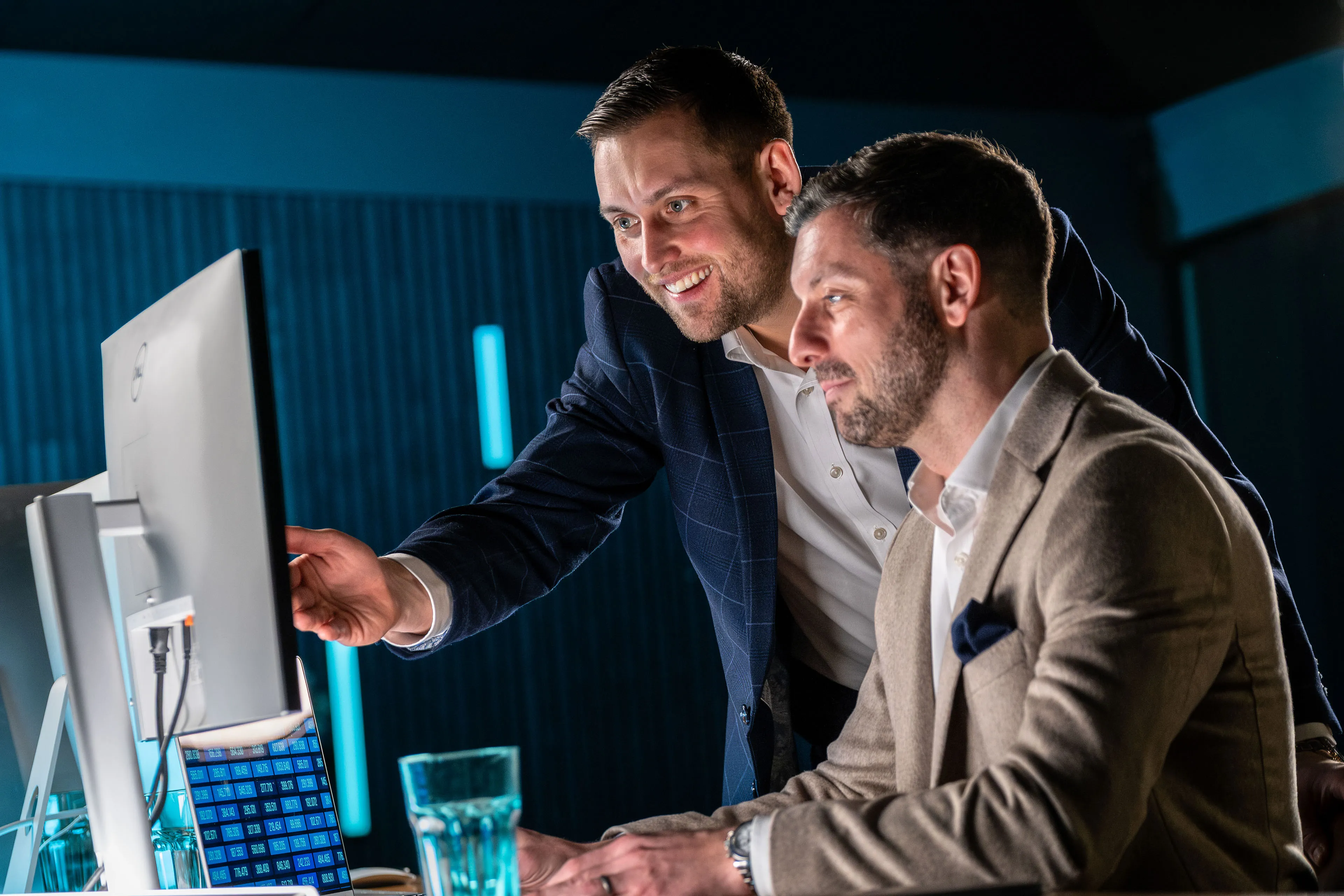Dan Collier smiling and pointing at a monitor as Brook Longhurst looks on during a discussion