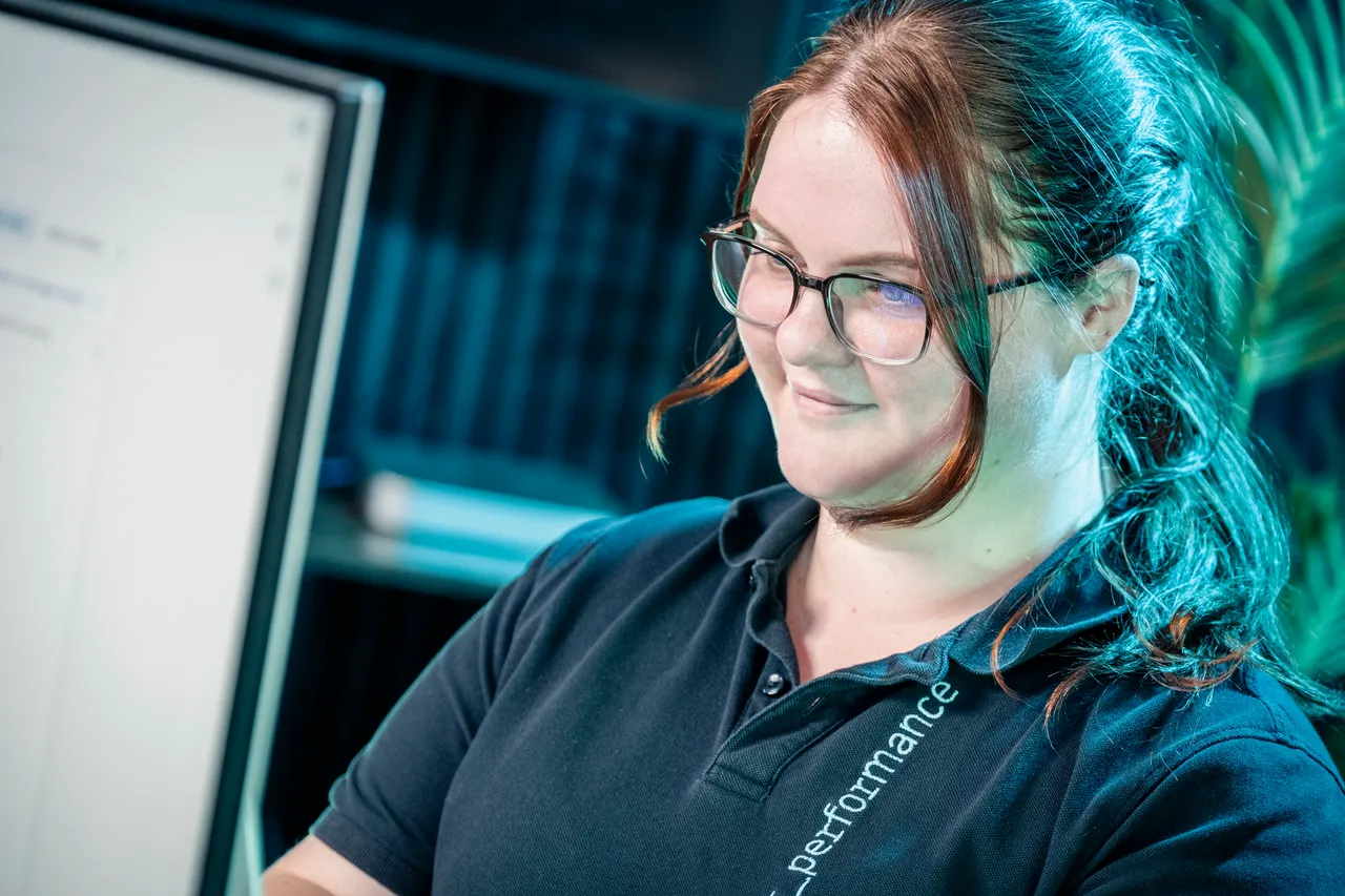 Paula Hamilton, accounts executive at DotPerformance Isle of Man, working on a laptop in the studio