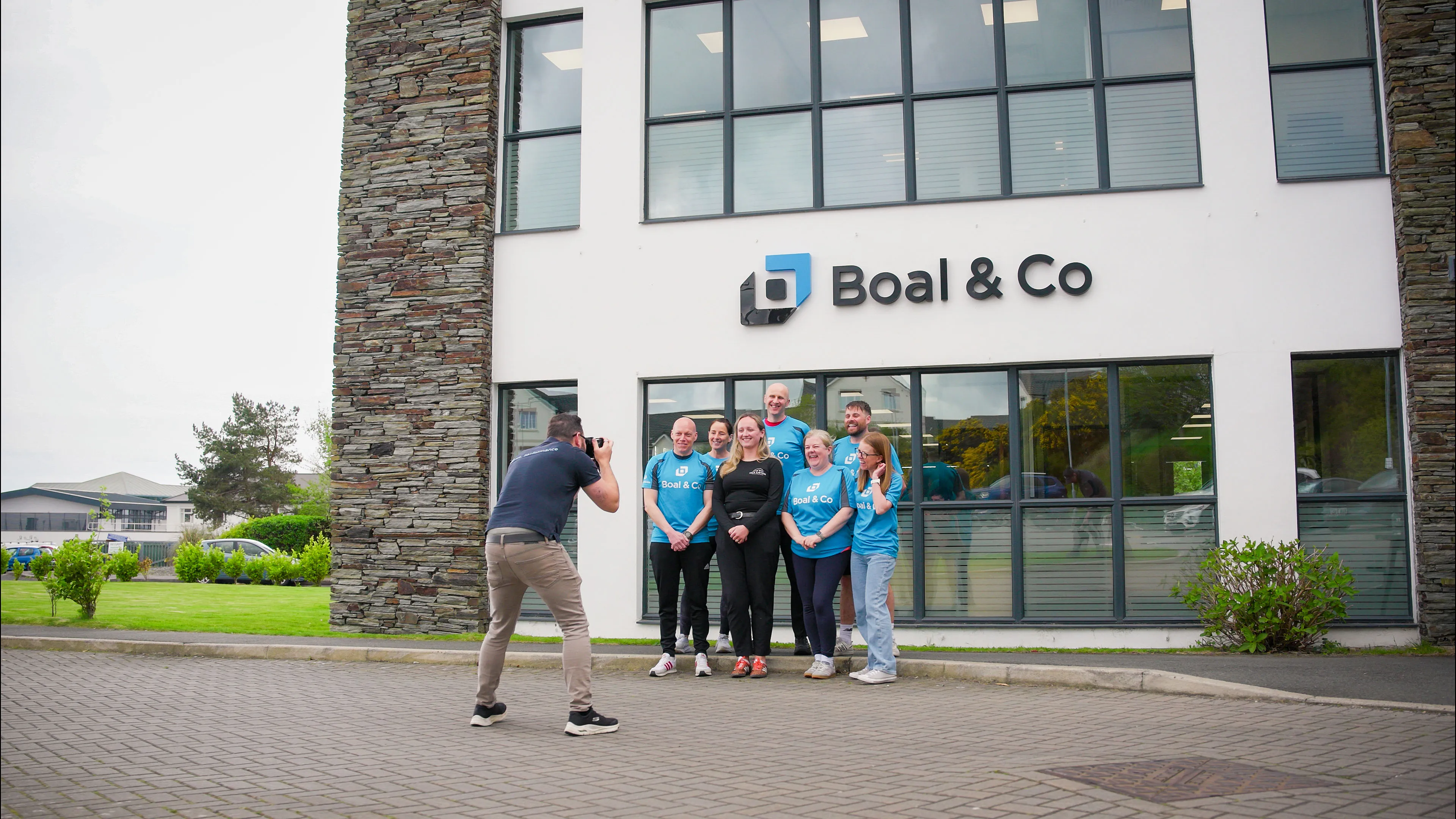Nico van Loggerenberg from DotPerformance photographing Greg Collins, Karen McHale,James Bassett, Christine Evans, Andrew Cover, Vicky Mackie and Jess Knight from Isle Listen outside the Boal & Co office in Douglas, Isle of Man