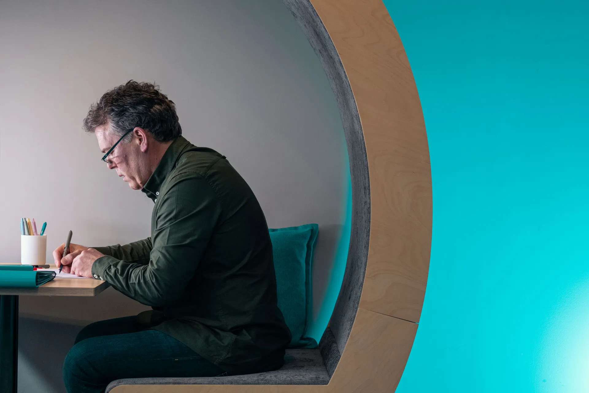 Jason Burton making notes in a work booth at the DotPerformance office