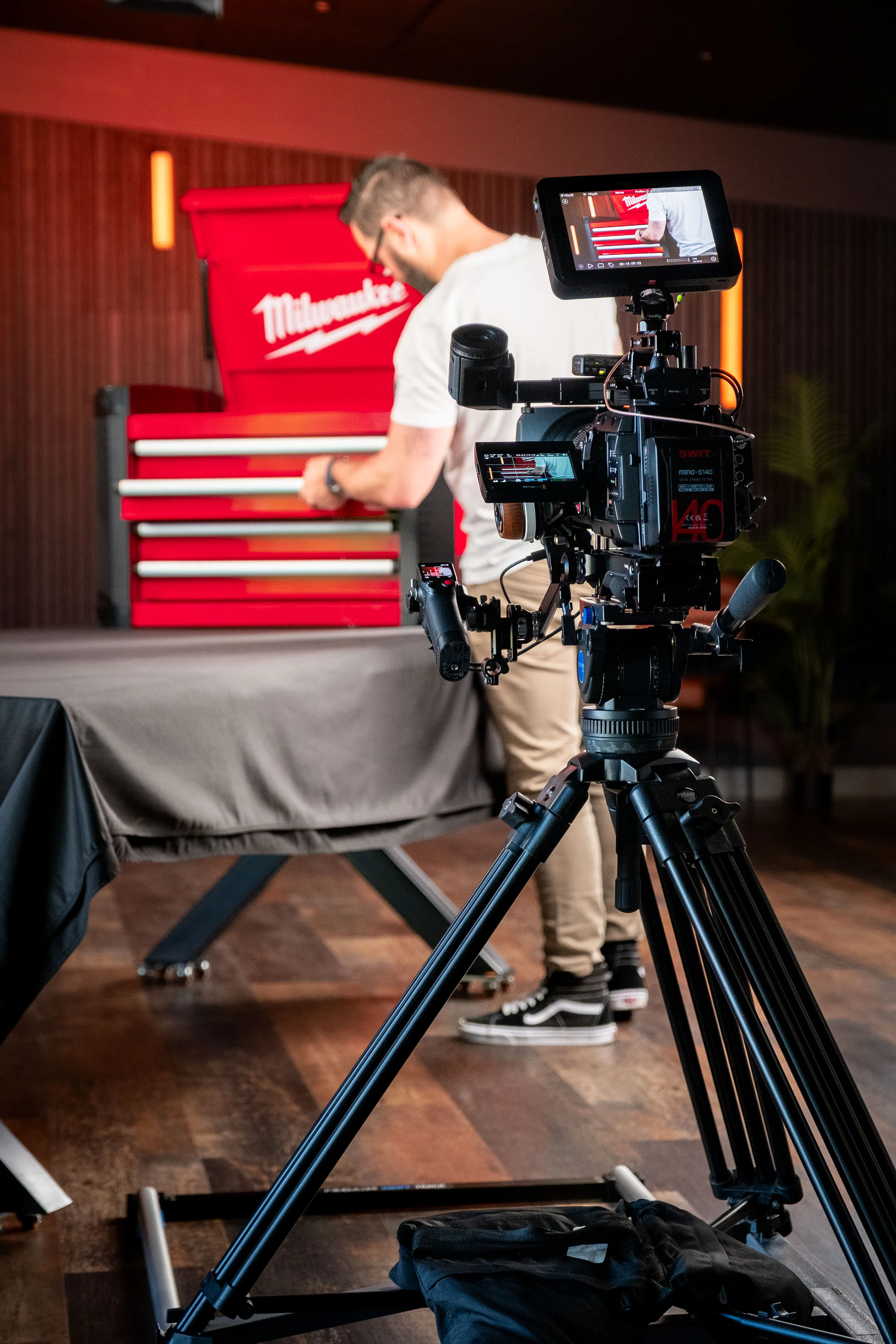 Nico van Loggerenberg walking alongside a Blackmagic Ursa Mini camera mounted on a PROAIM Swift Dolly System straight track, filming the Milwaukee STC30-1 Toolbox prize in the studio