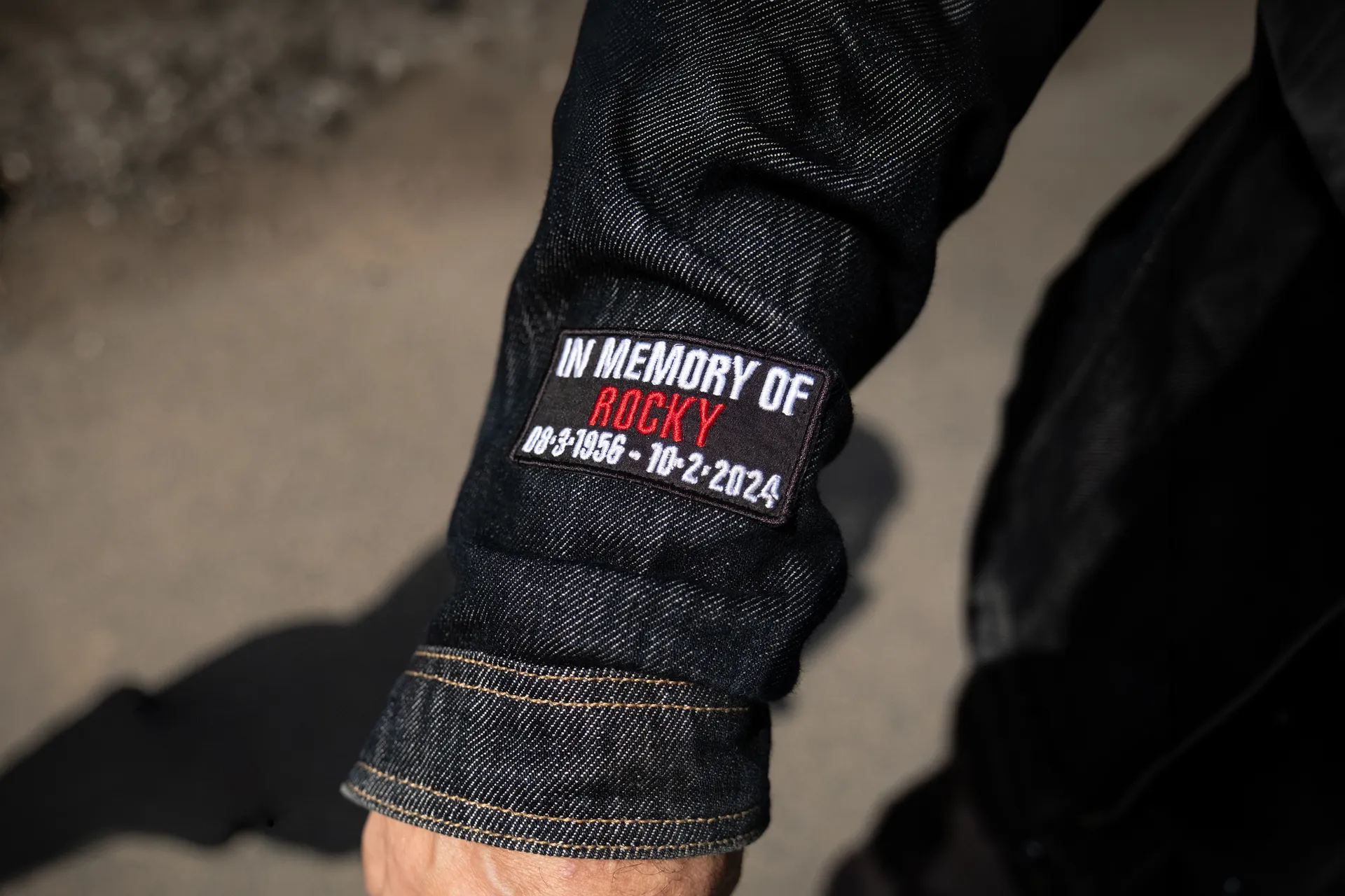 A jacket sleeve embroidered with an In memory of tribute, photographed for Behind the Tabard