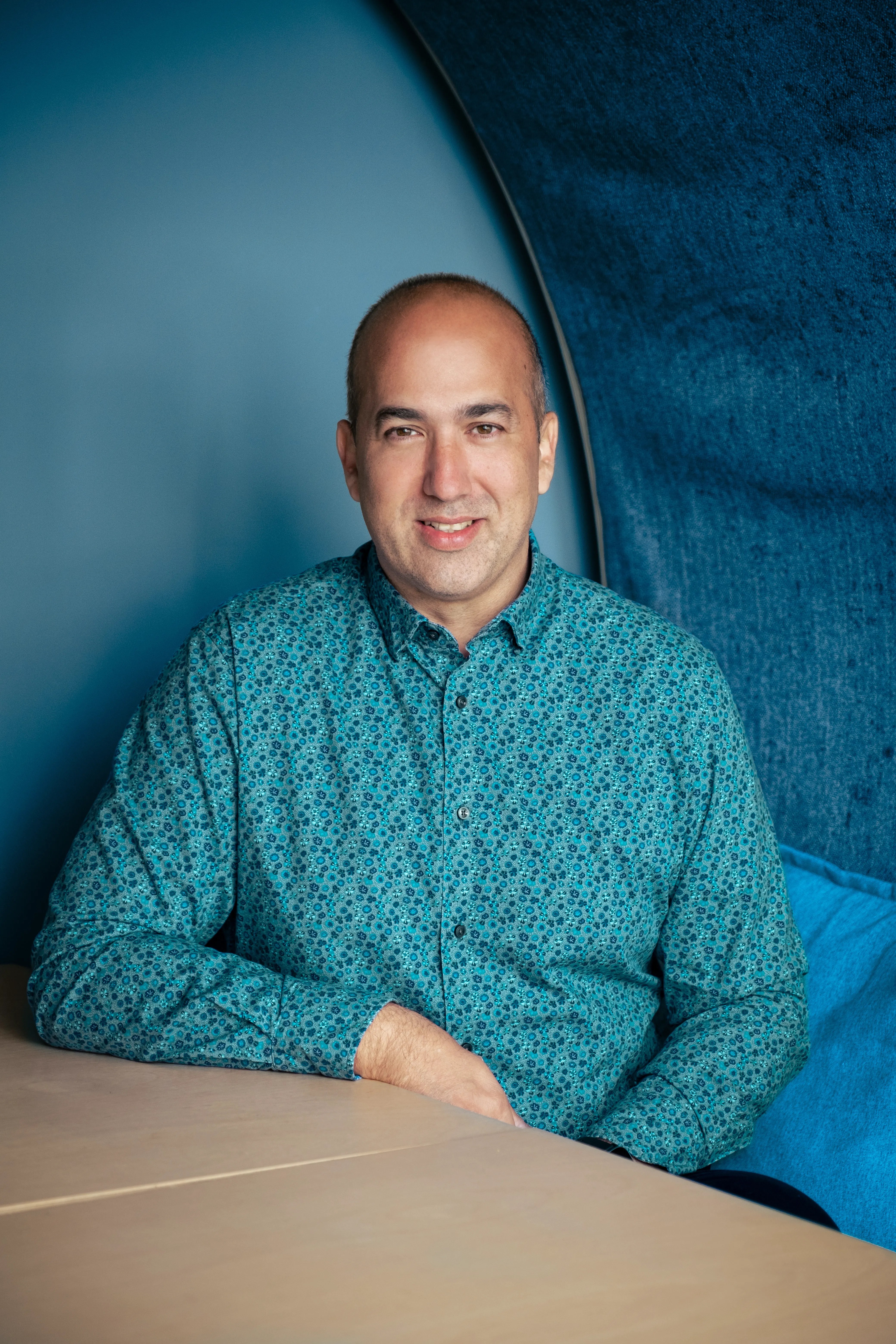 Claudiu Danila, Senior Developer at DotPerformance, seated and smiling in a studio booth at DotPerformance studios in Douglas, Isle of Man