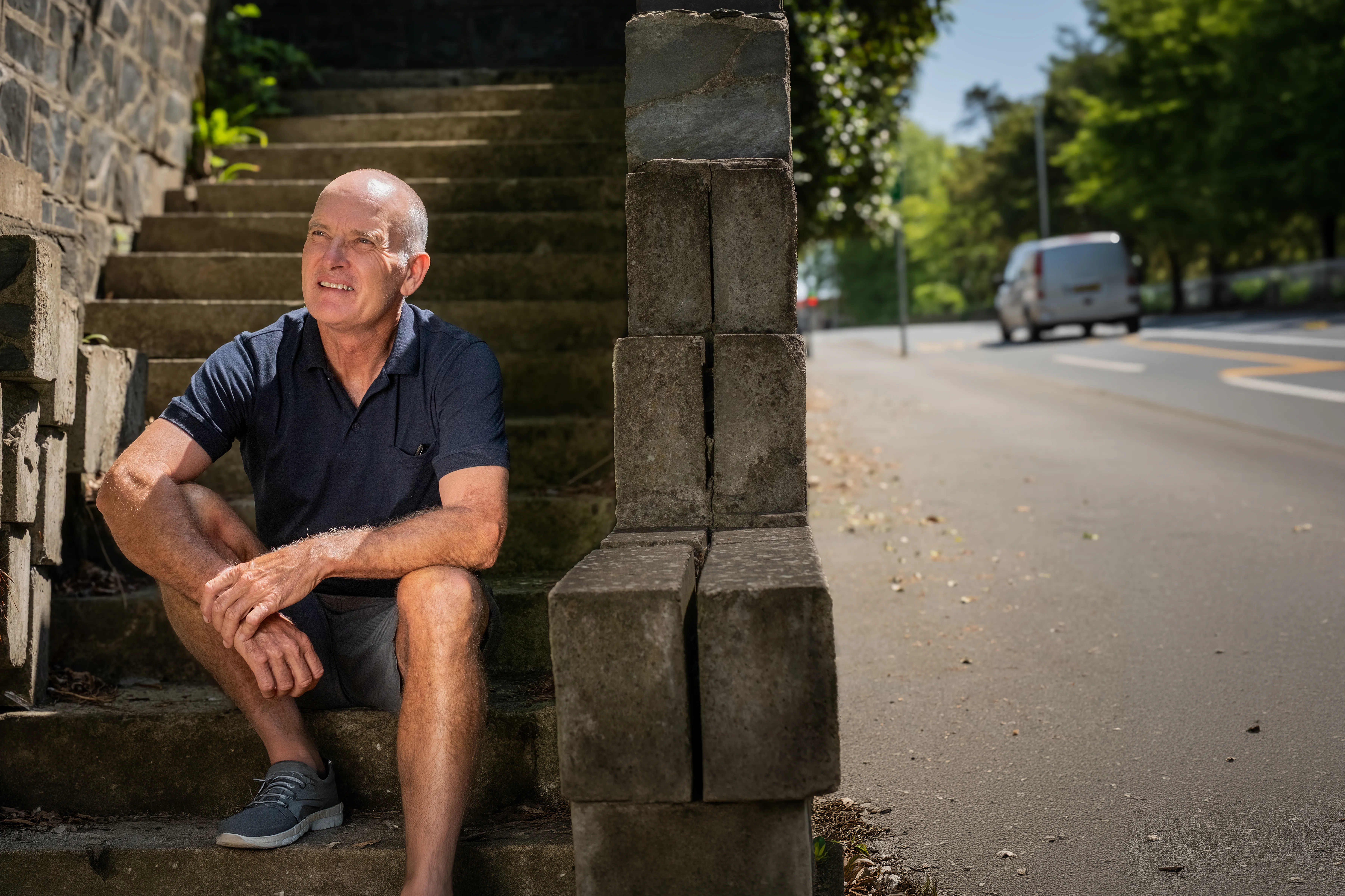 Calvin Entermann from Queensland, Australia, an Isle of Man TT Marshal, smiling outdoors for Behind the Tabard TT Marshals Series highlighting marshal stories, in a navy polo shirt