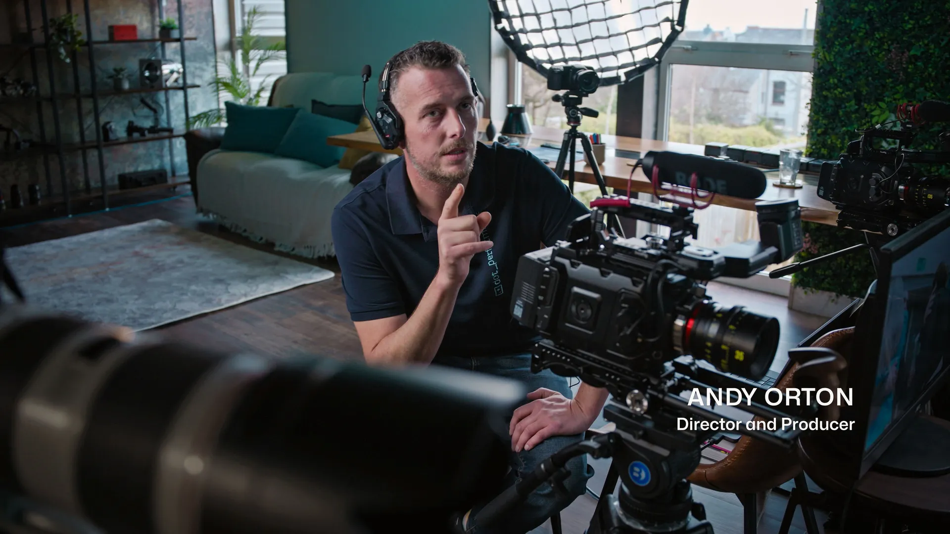 Andy Orton directing a DotPerformance video production shoot, with the URSA 12K Mini Pro BlackMagic Camera, Rode microphone, and softbox lighting visible on set