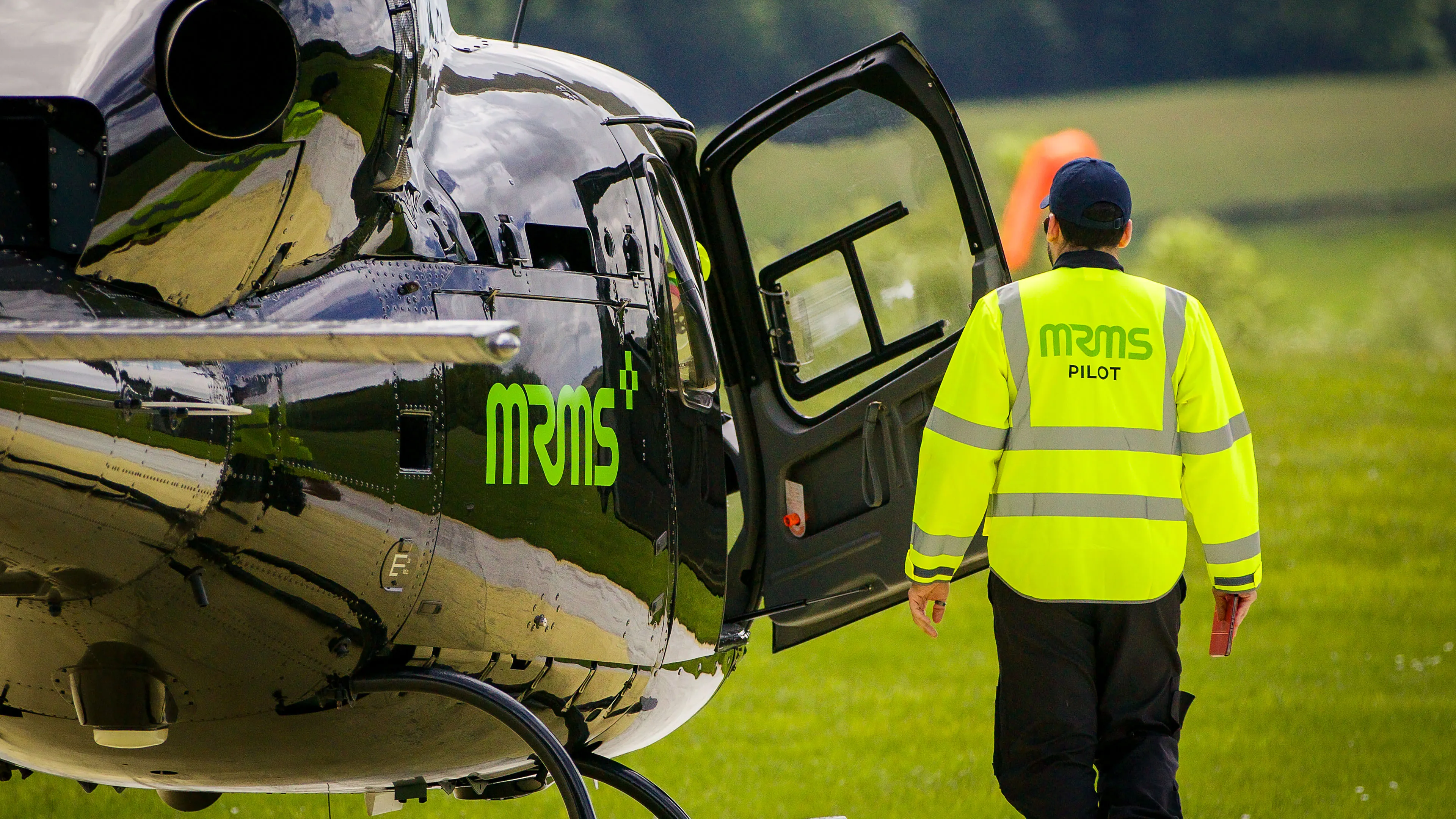 MRMS pilot walking towards the helicopter across the grass before takeoff