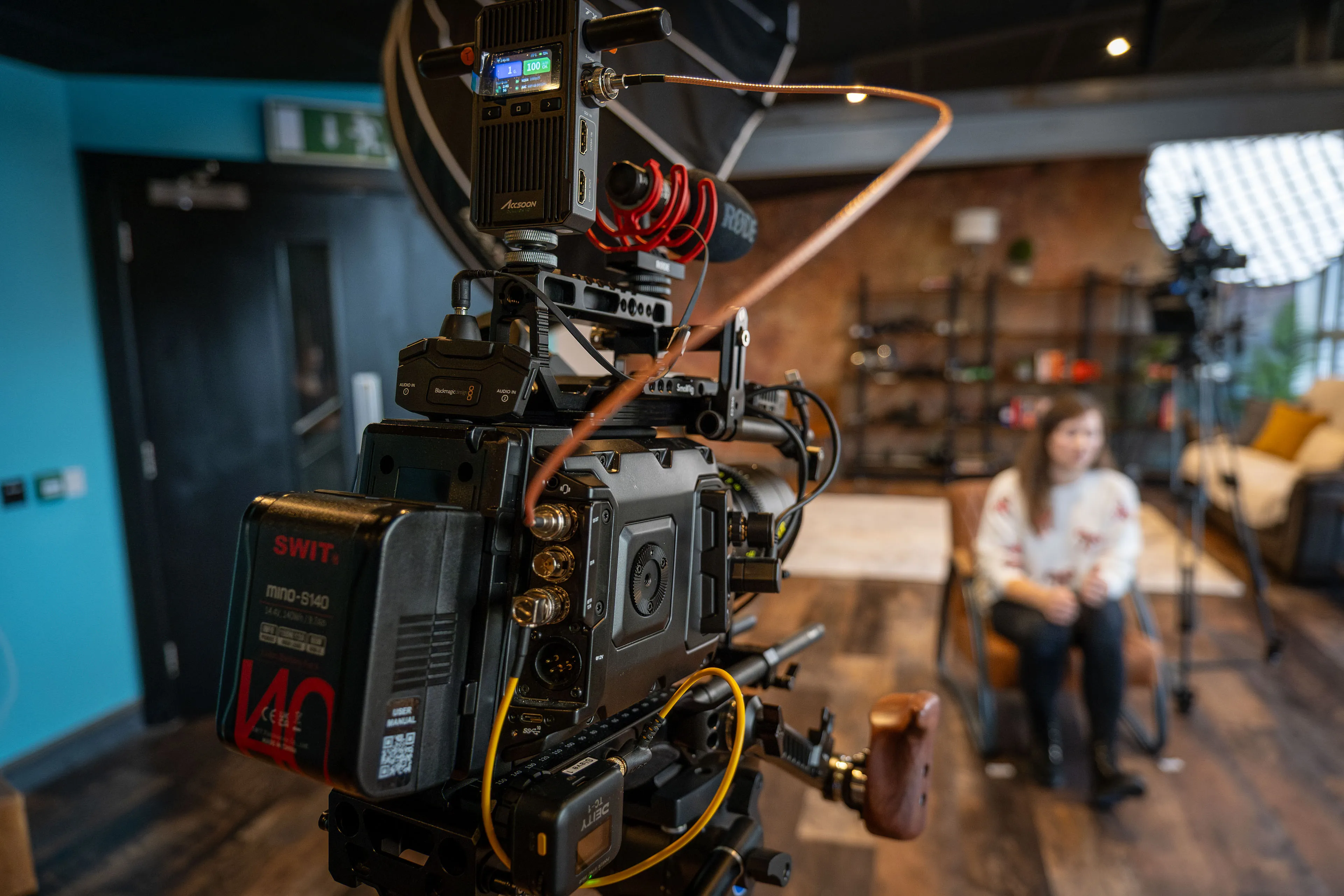 Oksana Fedorovych is seated for a multi-camera video interview at DotPerformance studios on the Isle of Man, with URSA Blackmagic Mini Pro 12K camera rigs and large softbox lighting visible in the foreground