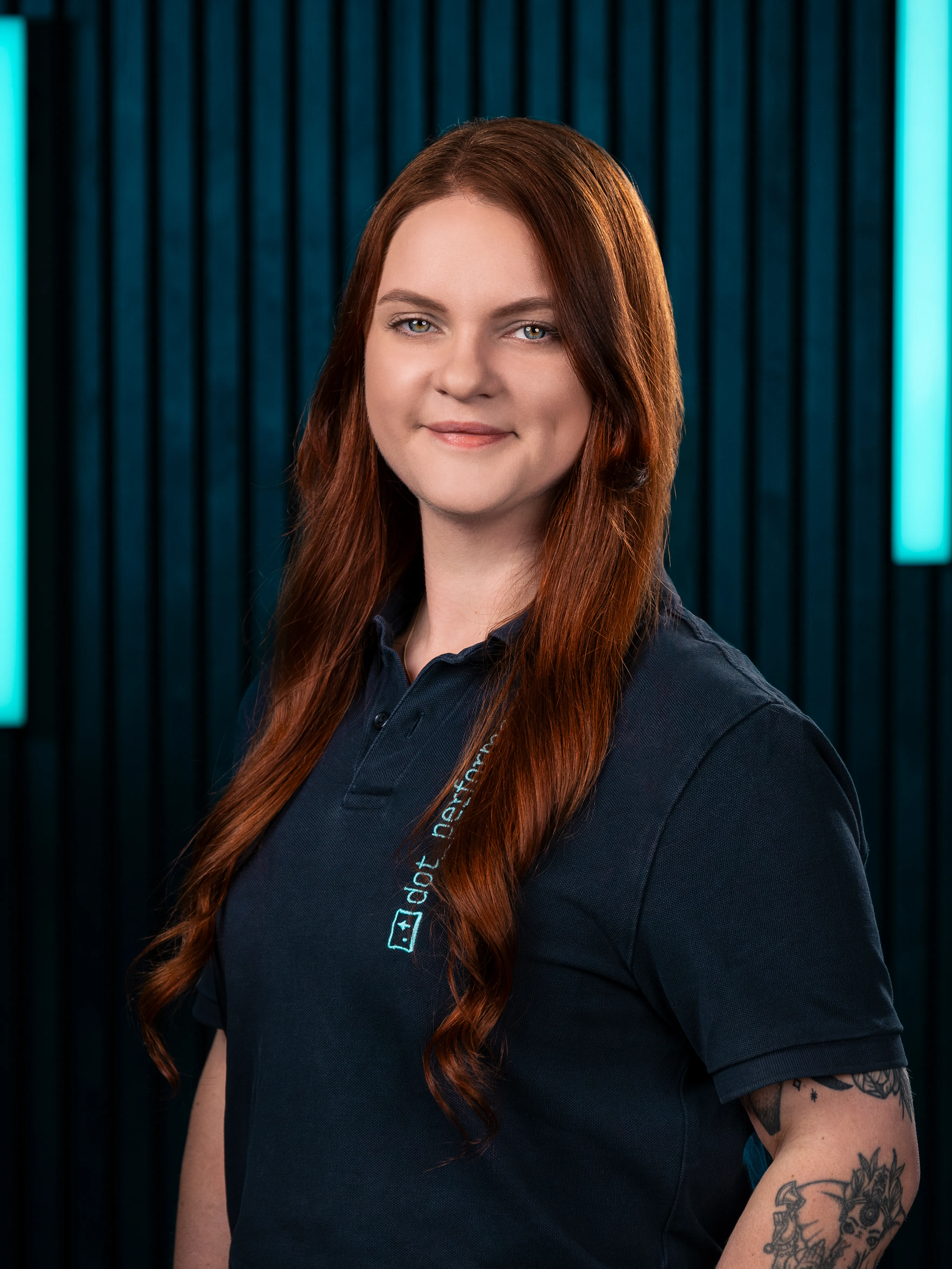 Paula, accounts executive at Dot Performance, smiling as she poses for headshot wearing branded polo shirt.