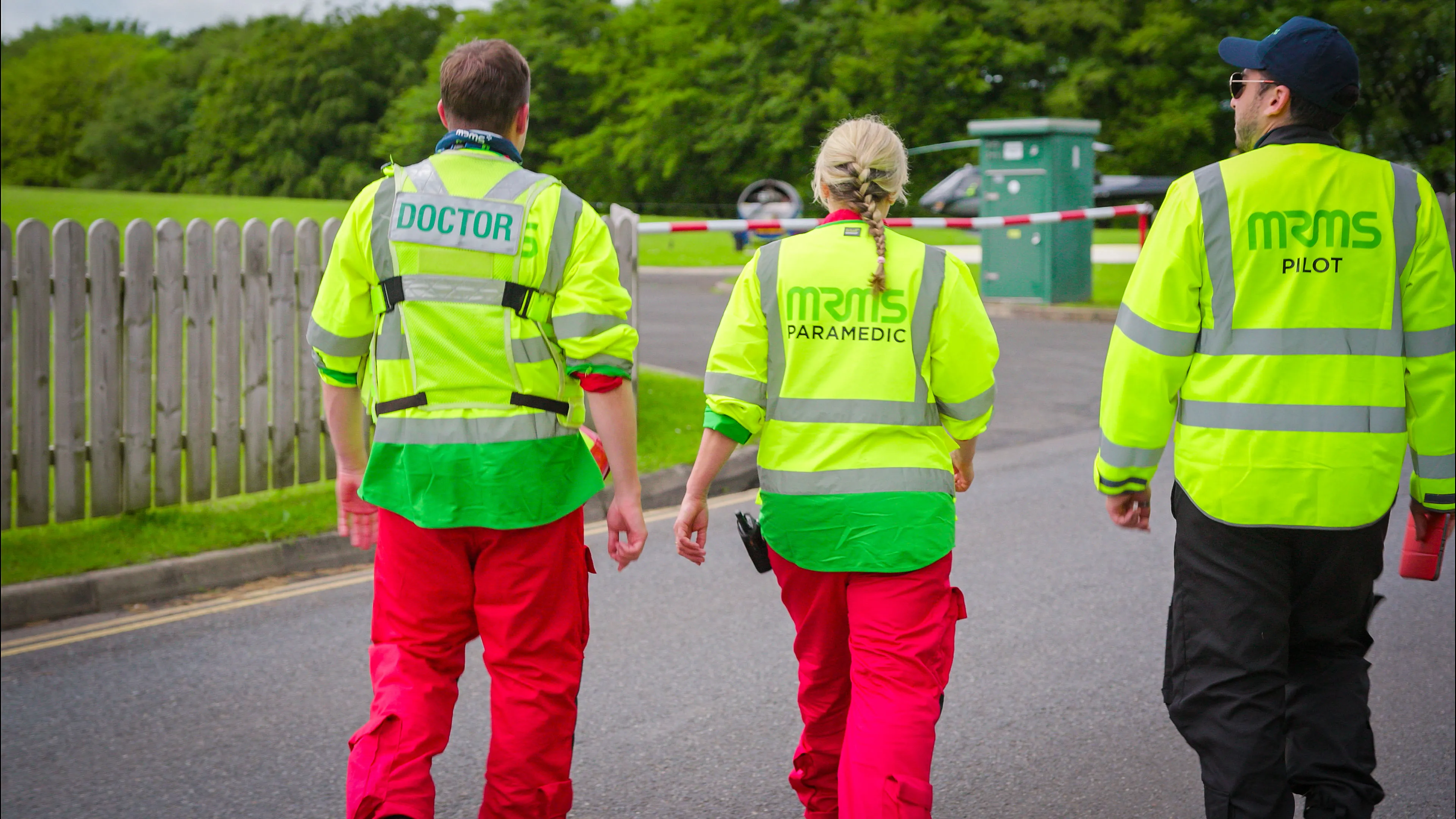 MRMS doctor, paramedic and pilot walking towards the helipad, viewed from behind