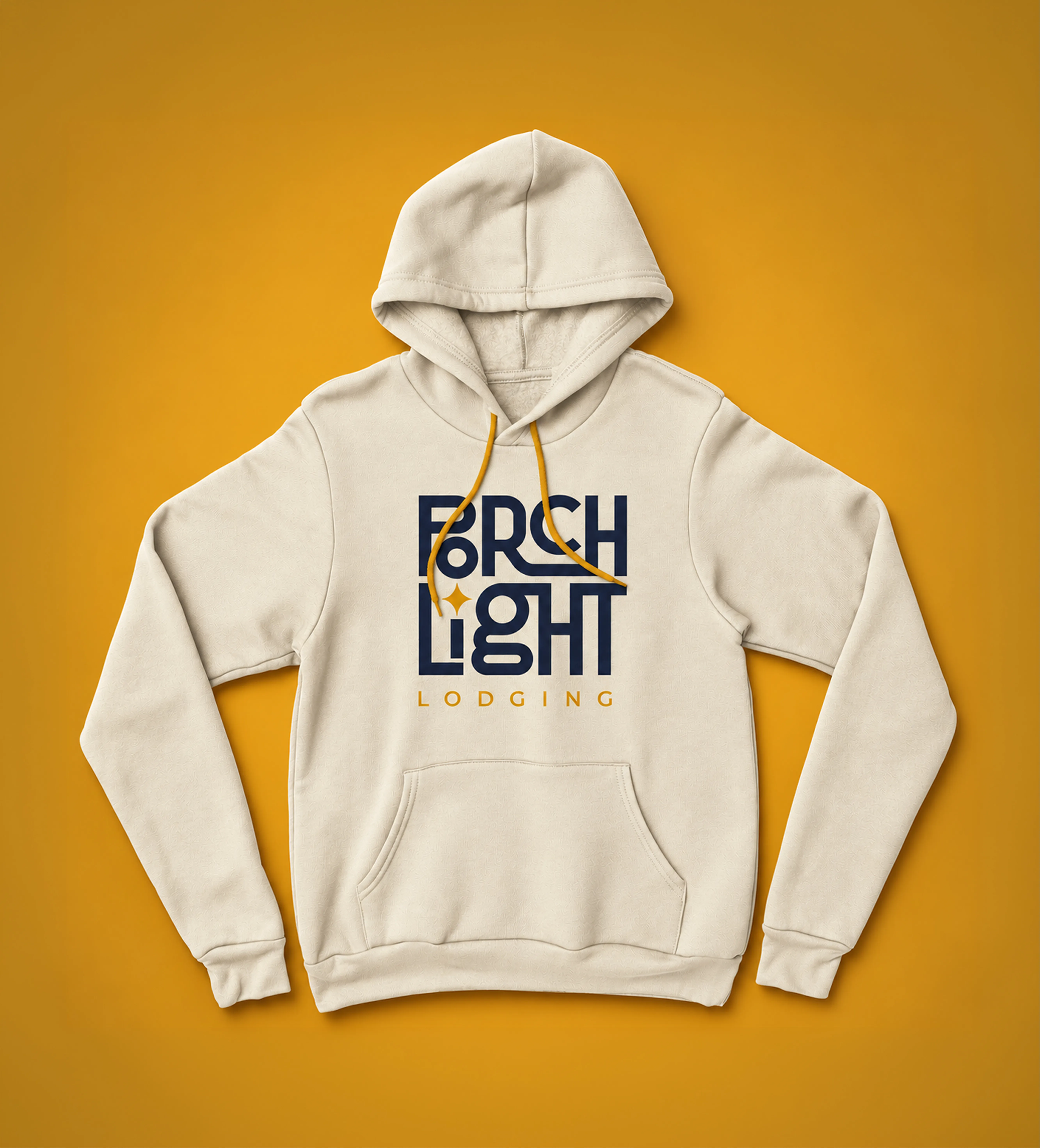 Natural cream PorchLight Lodging hoodie with a navy logo, gold star and gold drawstrings, on a gold background