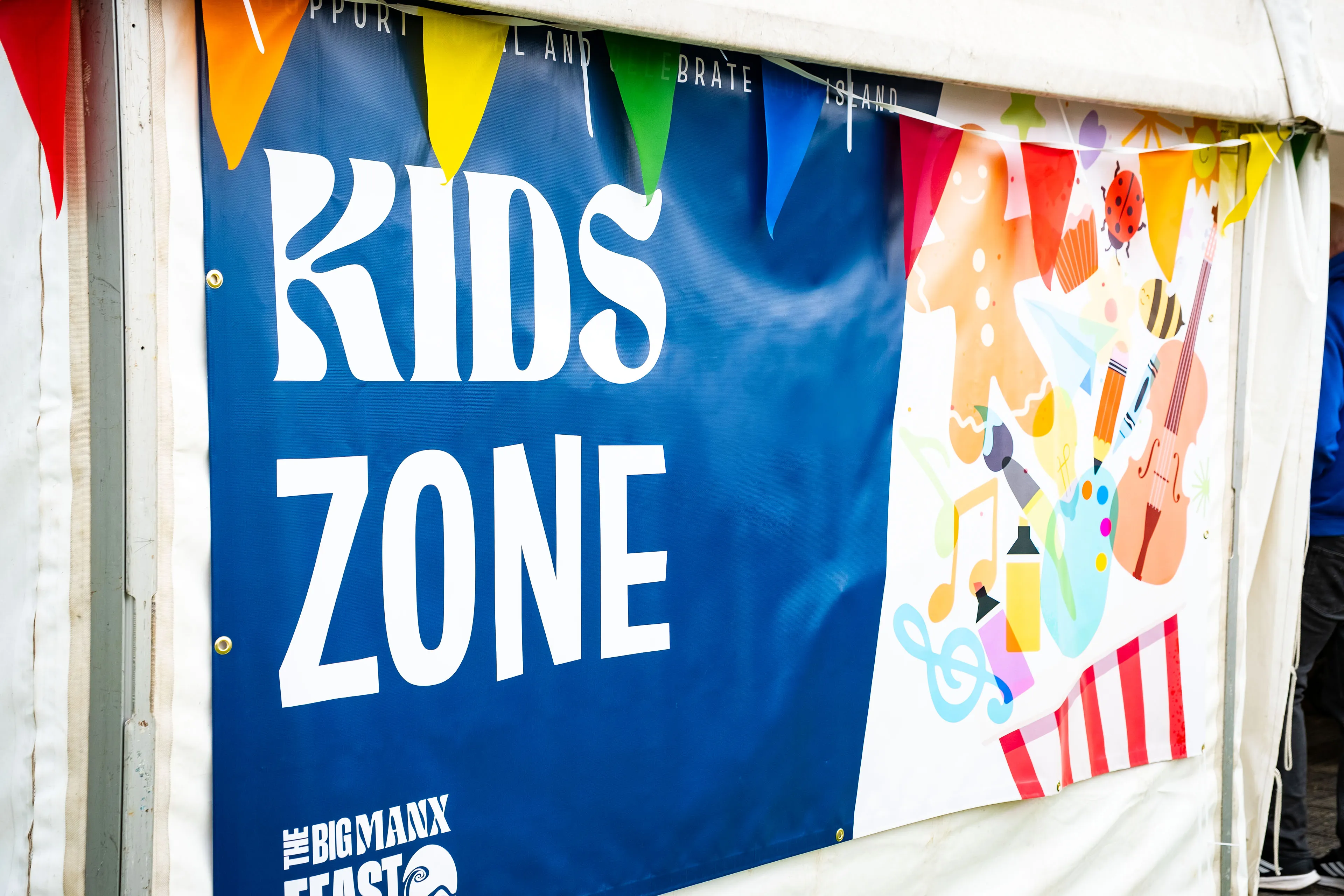 The Kids Zone banner with illustrated music and craft icons at the Big Manx Feast