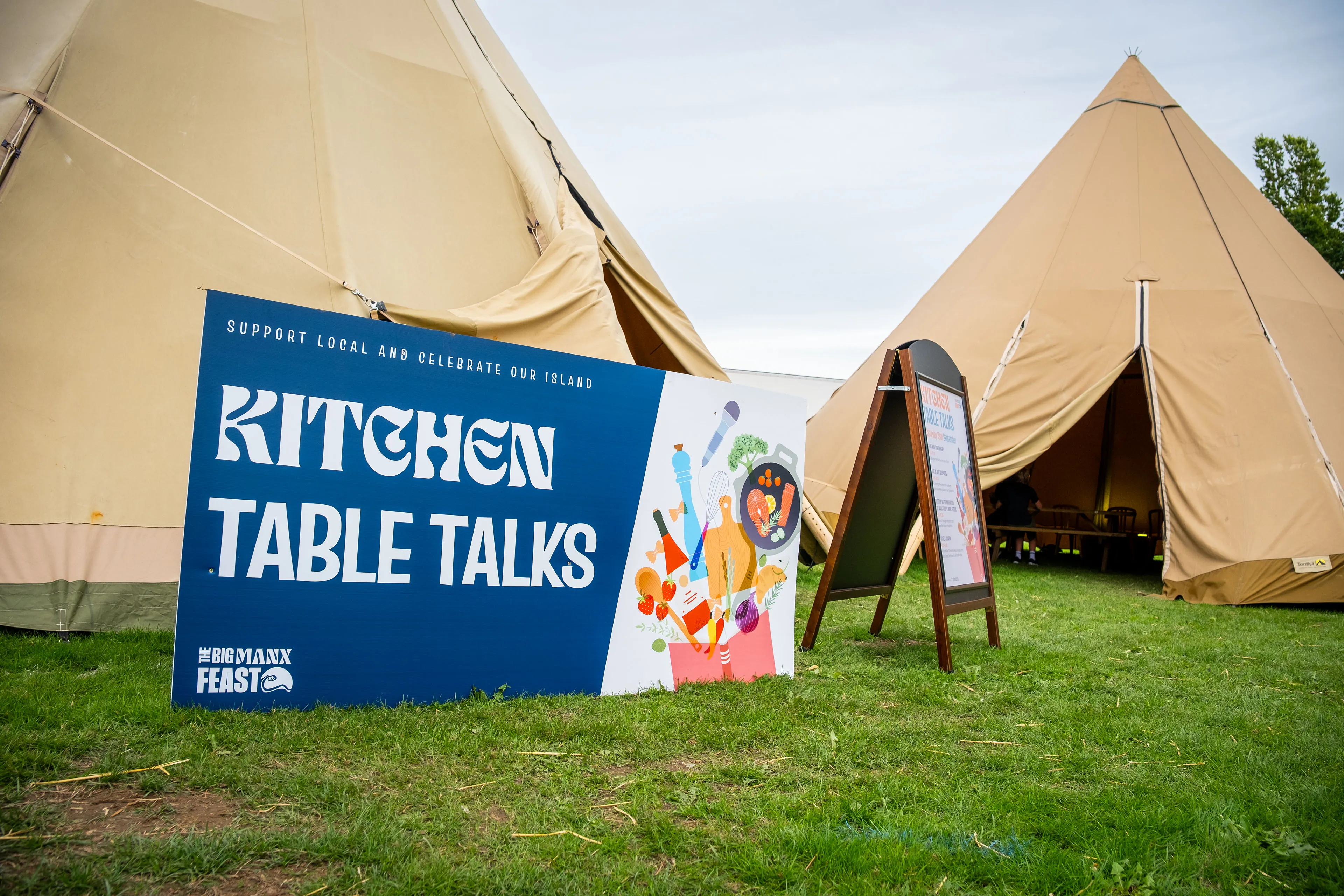 The Kitchen Table Talks banner standing outside the bell tent marquees at the Big Manx Feast