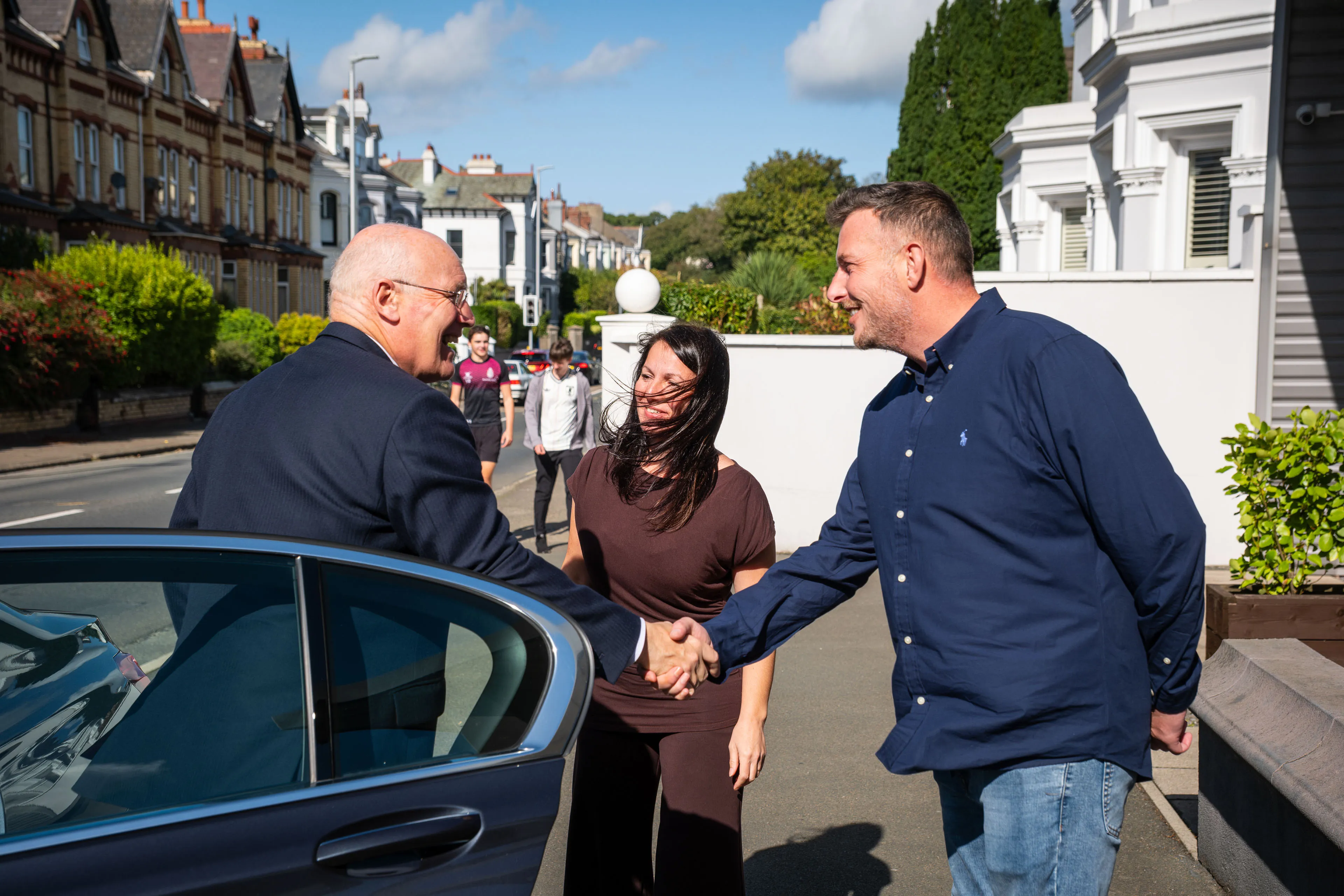 Lieutenant General Sir John Lorimer KCB DSO MBE shaking hands with Andy Orton as Raluca Matei welcomes him outside DotPerformance