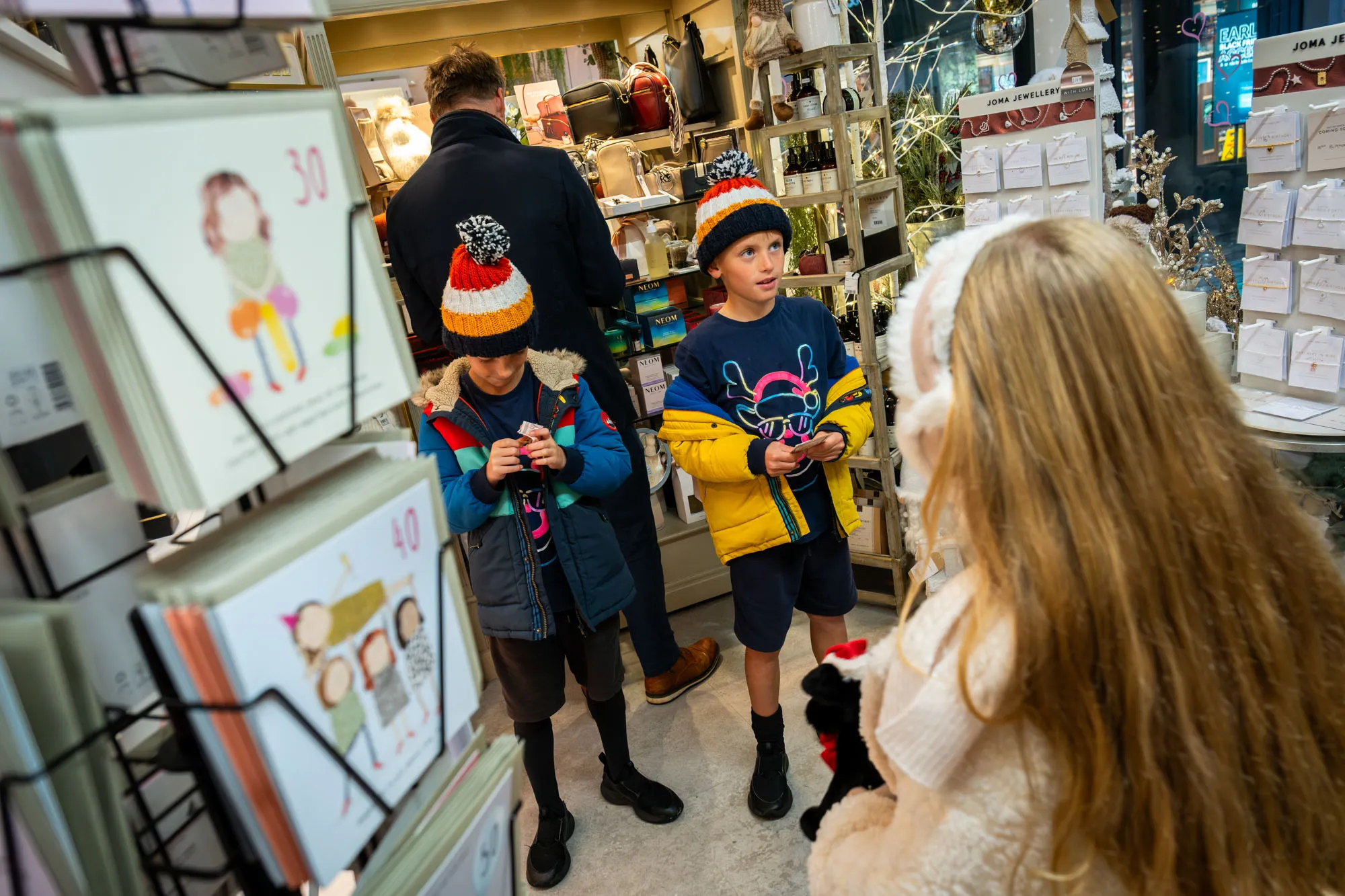 Albert Orton, Arthur Orton and Vivi Quaye browsing inside Magazzino on Strand Street, Douglas, Isle of Man, during filming of the Business Isle of Man Buy Local Christmas campaign by DotPerformance
