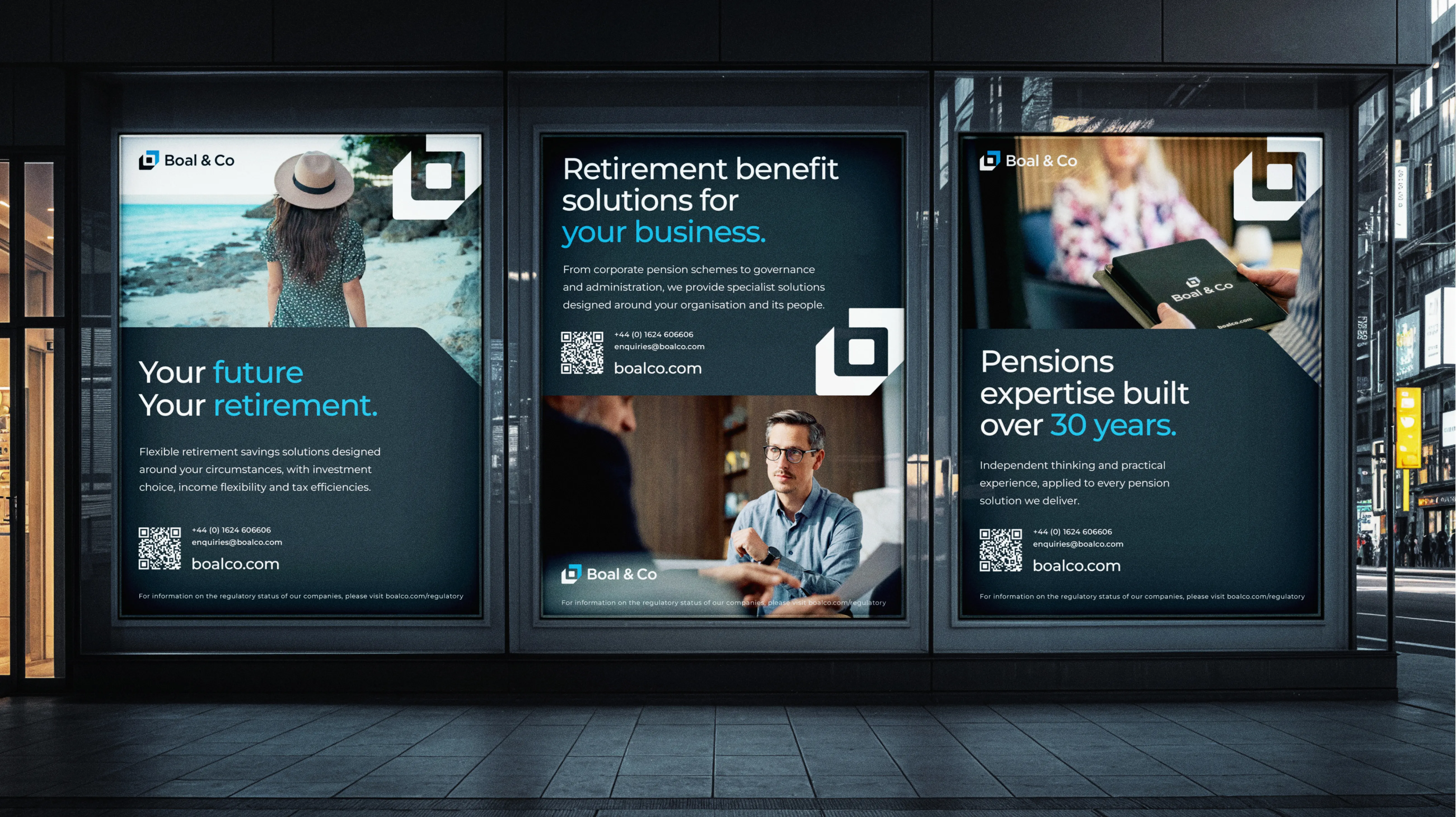 Three Boal & Co posters in a lit shopfront at night, promoting retirement savings, workplace pension solutions and 30 years of expertise