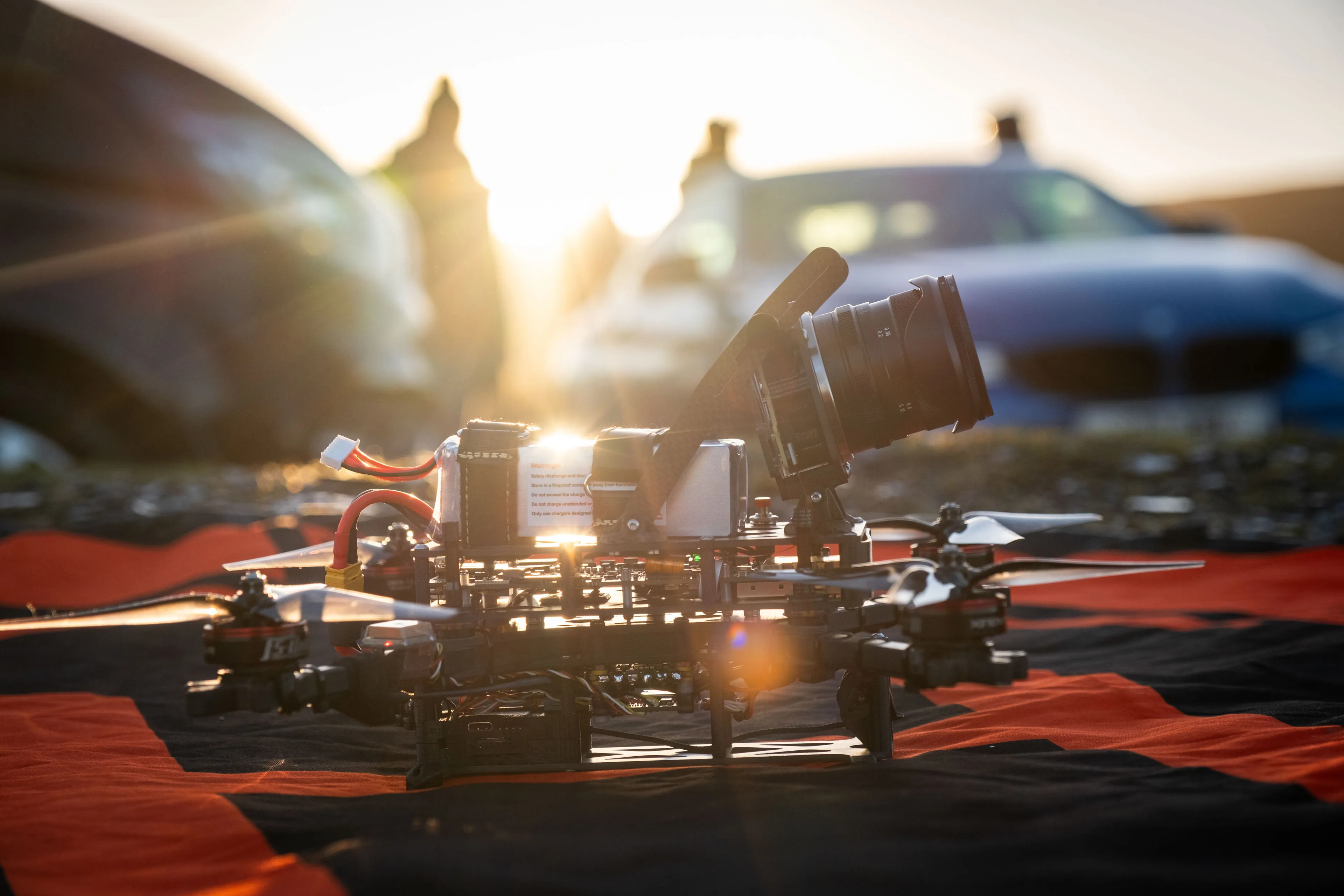 FPV cinelifter rig carrying a cinema camera on the ground at golden hour during a DotPerformance video production shoot on the Isle of Man