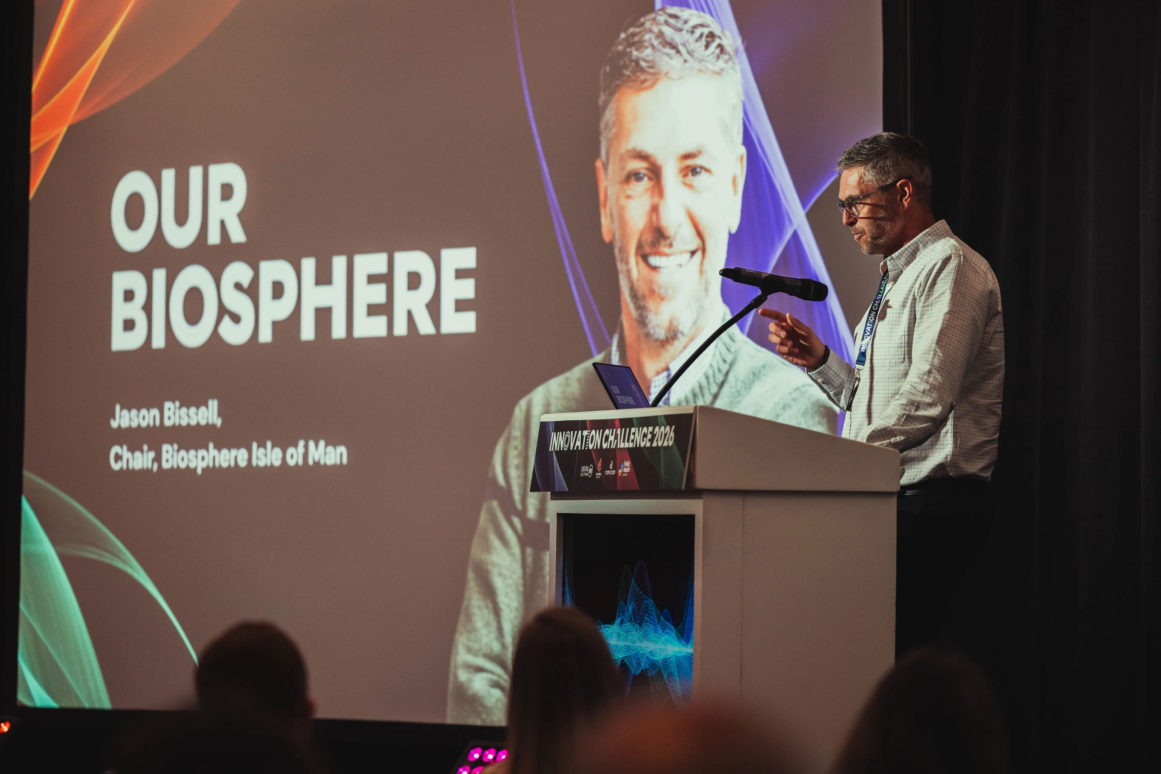 Jason Bissell, Chair of Biosphere Isle of Man, presenting beside an "Our Biosphere" title slide