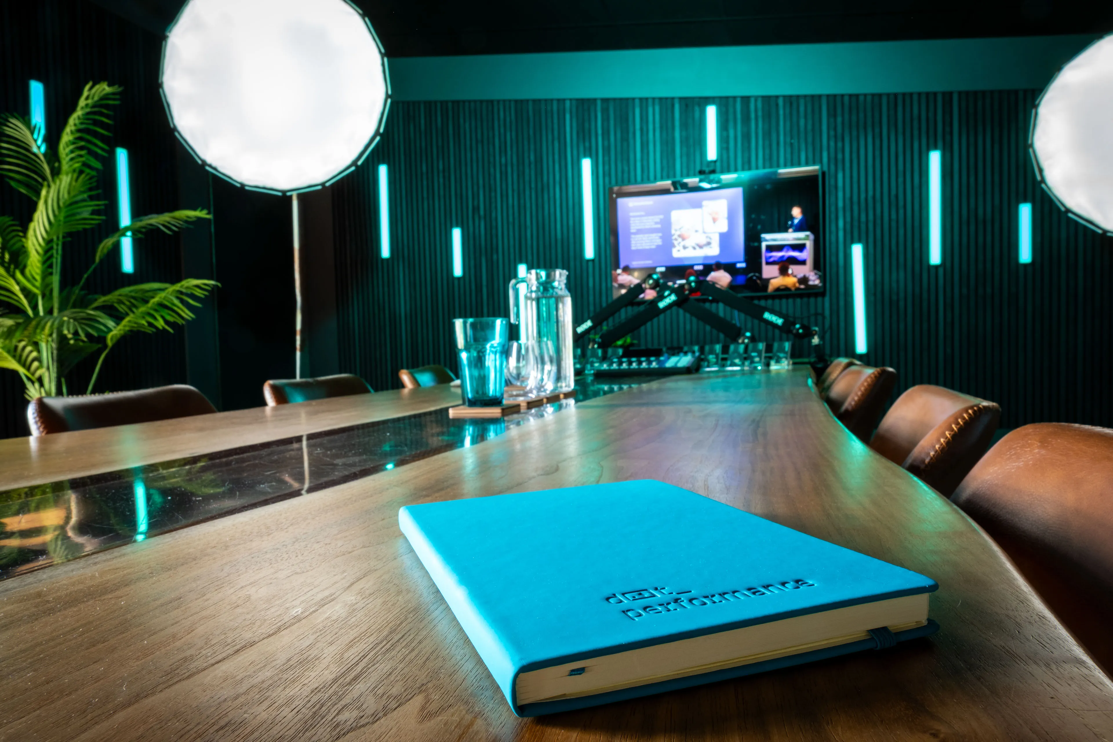 Close-up of the DotPerformance notebook with Andy Orton presenting to the audience visible on the screen behind