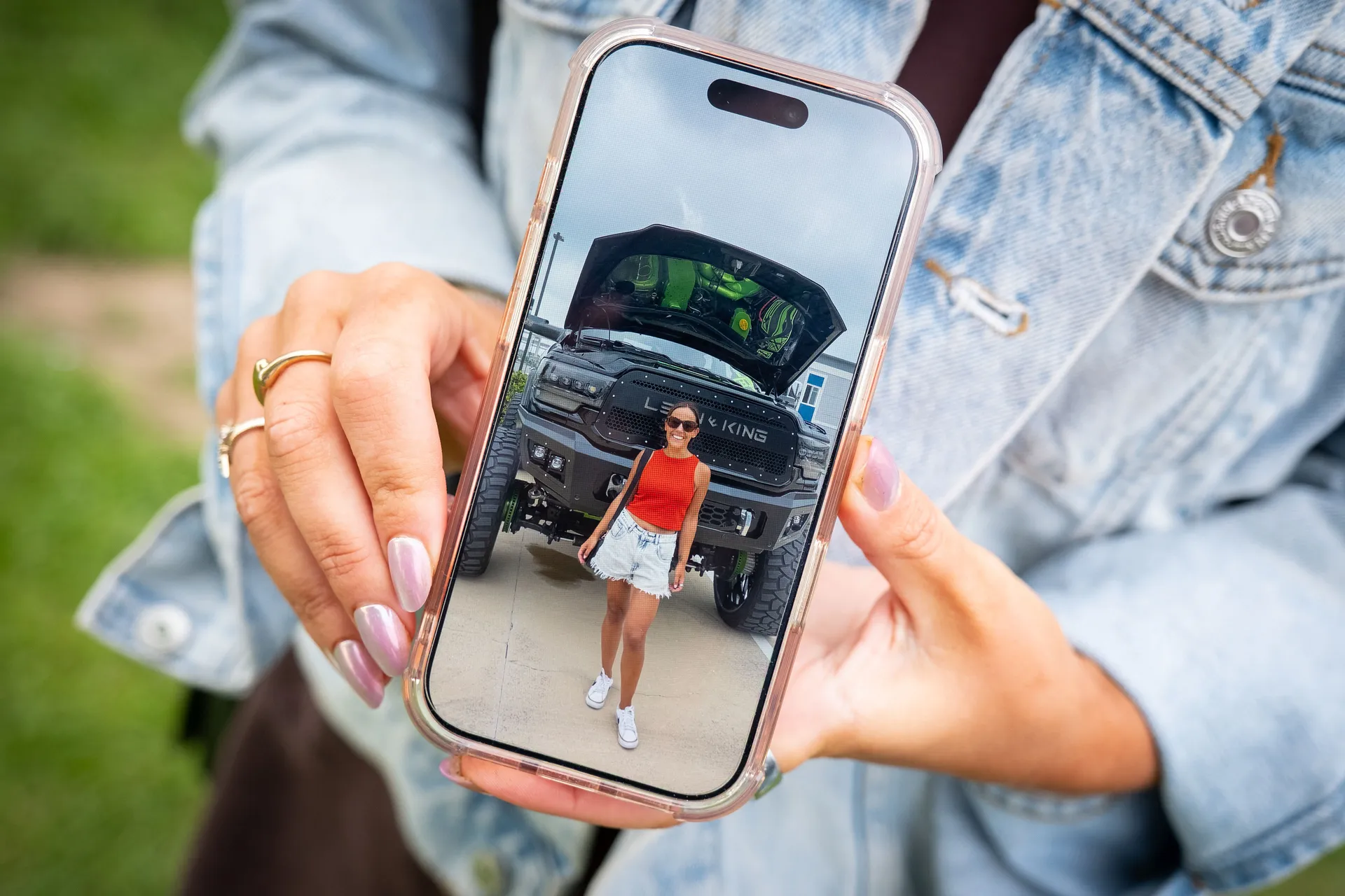 A hand holding a phone showing a Behind the Tabard portrait