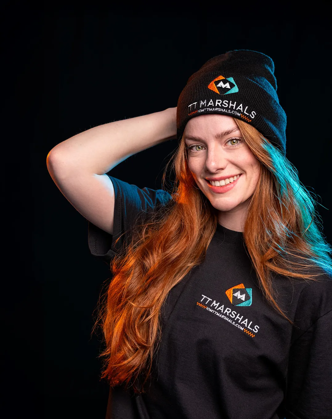 Ella Garvey wearing the official TT Marshals 2026 black beanie and t-shirt, featuring the TT Marshals logo. Exclusive marshal merchandise for the Isle of Man TT 2026.