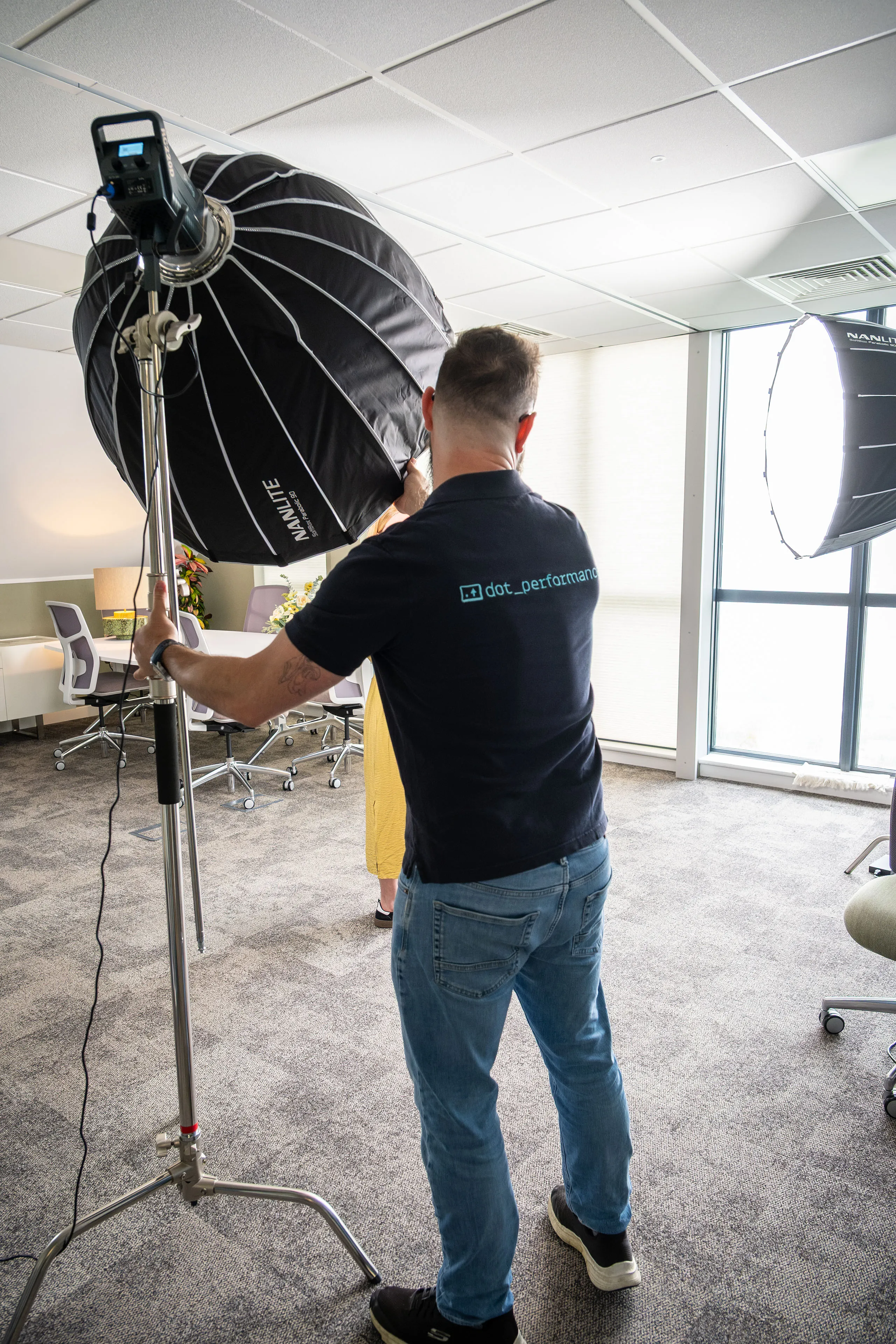 Nico van Loggerenberg adjusting a Nanlite Parabolic 90 softbox while lighting a portrait session at Boal & Co offices.